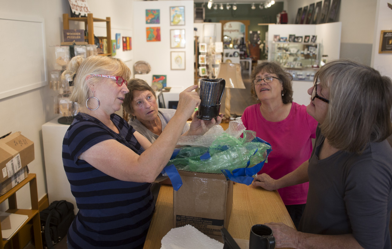  From left to right, artists Ann Judy, Rene Olson, Terry Fortkamp, and Elizabeth Brown look at a ceramic mug that will be on display at their national cup show in Starbrick Gallery in Nelsonville, Ohio on September 19, 2015. The gallery hosts the cup
