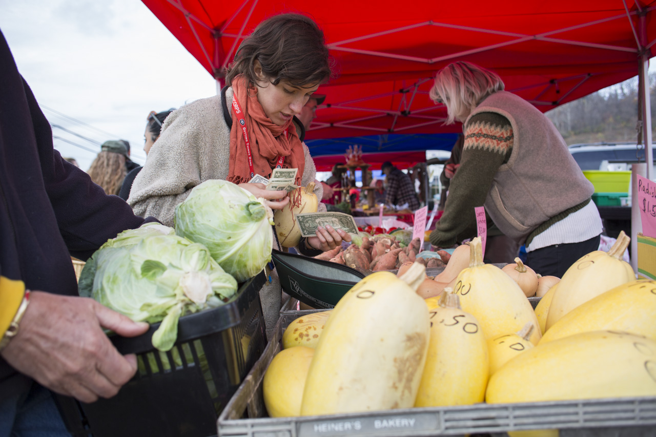  COMCorps member Javi Devia, of Athens, Ohio, buys food for Community Food Initiative at the Athens farmers market on November 7, 2015 with money that was donated at the donation station the week before. 