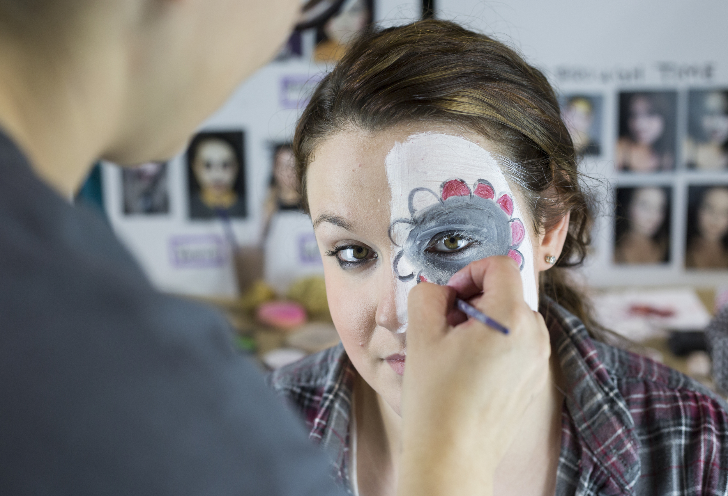  Abby Barnett, a junior at Vinton County High School, gets her face painted with Day of the Dead makeup by Kristen Fechtel, left, a senior studying scenic painting at Ohio University at the Student Expo in Ohio University's Convocation Center on Apri