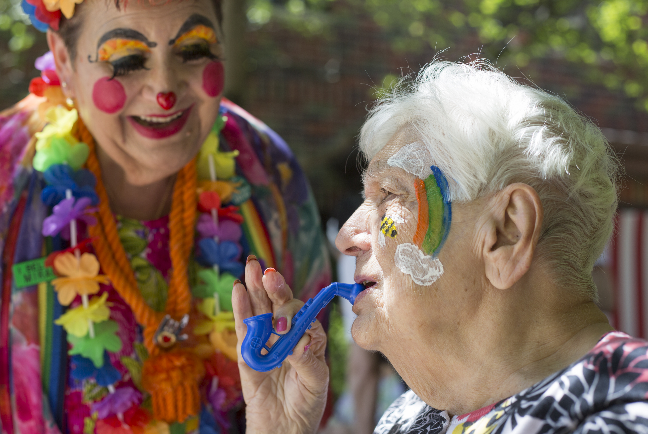  Natalie Shoop, left, dressed as Lovie the Clown, watches as Martha Parise, a resident of the nursing home Villa St. Joseph, blows into a saxophone-shaped whistle Shoop gave her during a carnival at Villa St. Joseph in Baden, Pa. on June 3, 2017. The