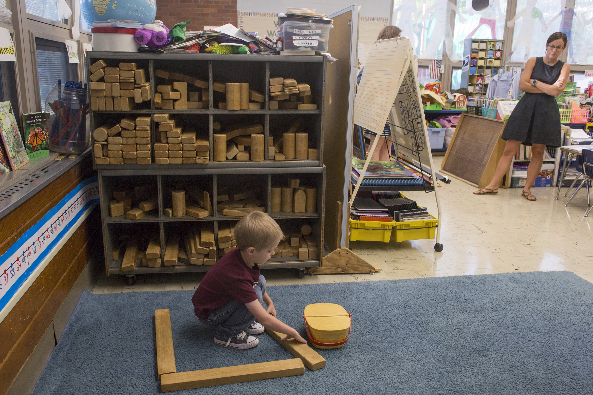  Josiah plays with blocks in his kindergarten class while his special  education teacher, Colleen Post, watches. The kindergarten class spends the majority of the morning in open play, during which Josiah has short  interactions with his classmates a
