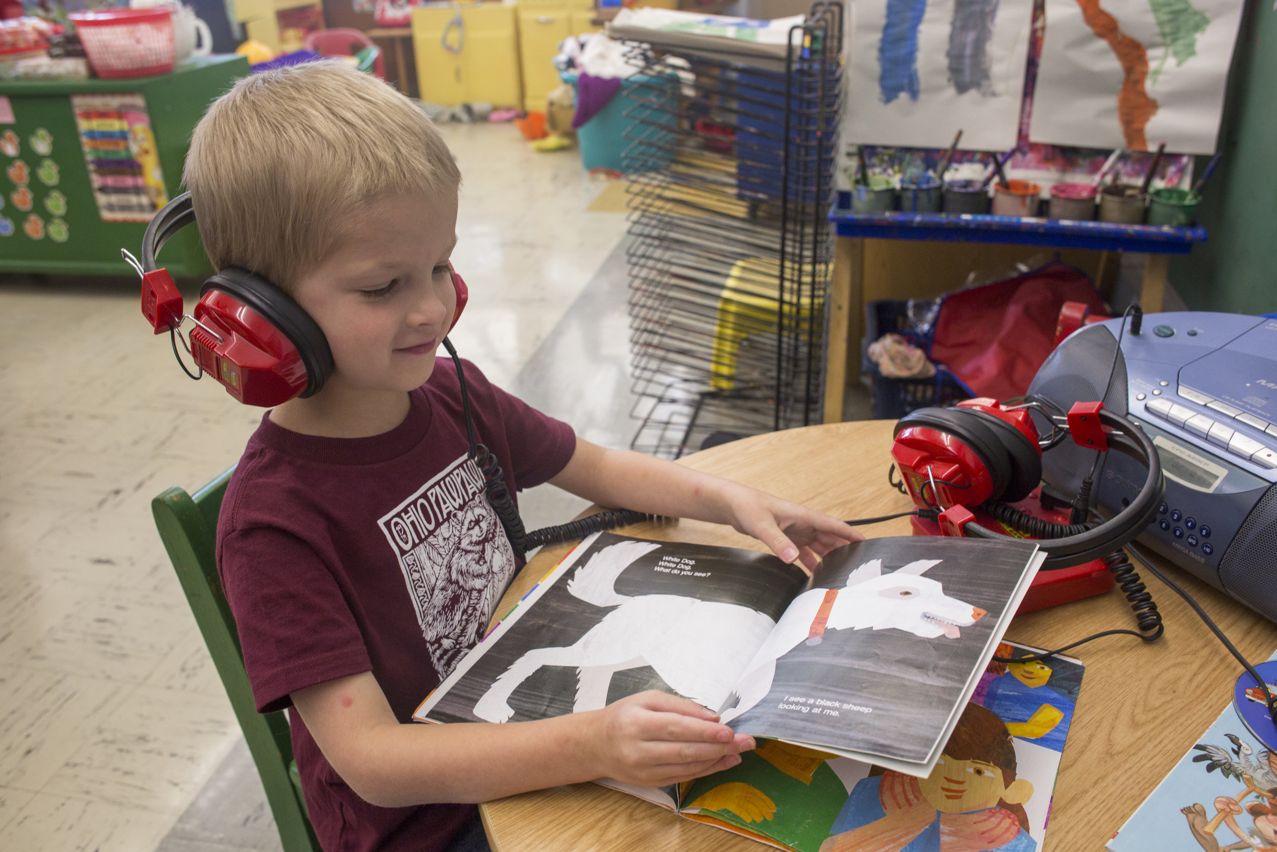  Josiah pauses to look at a picture of a dog while flipping through and listening to the book Brown Bear, Brown Bear, What Do You See? in his kindergarten class. 