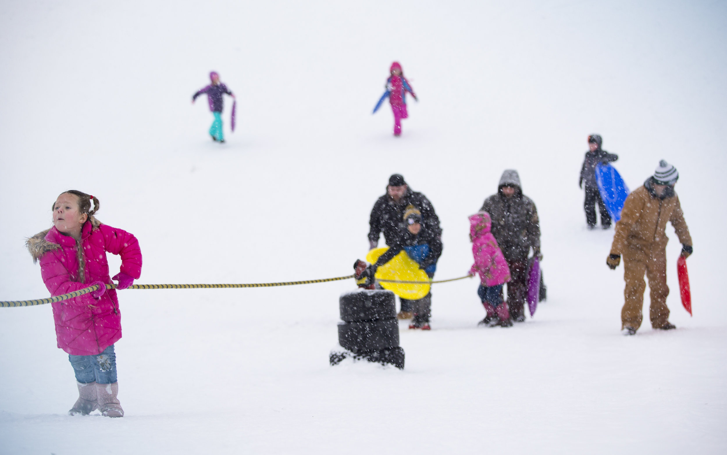  Kids and adults climb up a hill at Wick Recreation Area in Youngstown, Ohio, to go sled riding during a heavy snow storm on Jan. 19, 2019. 