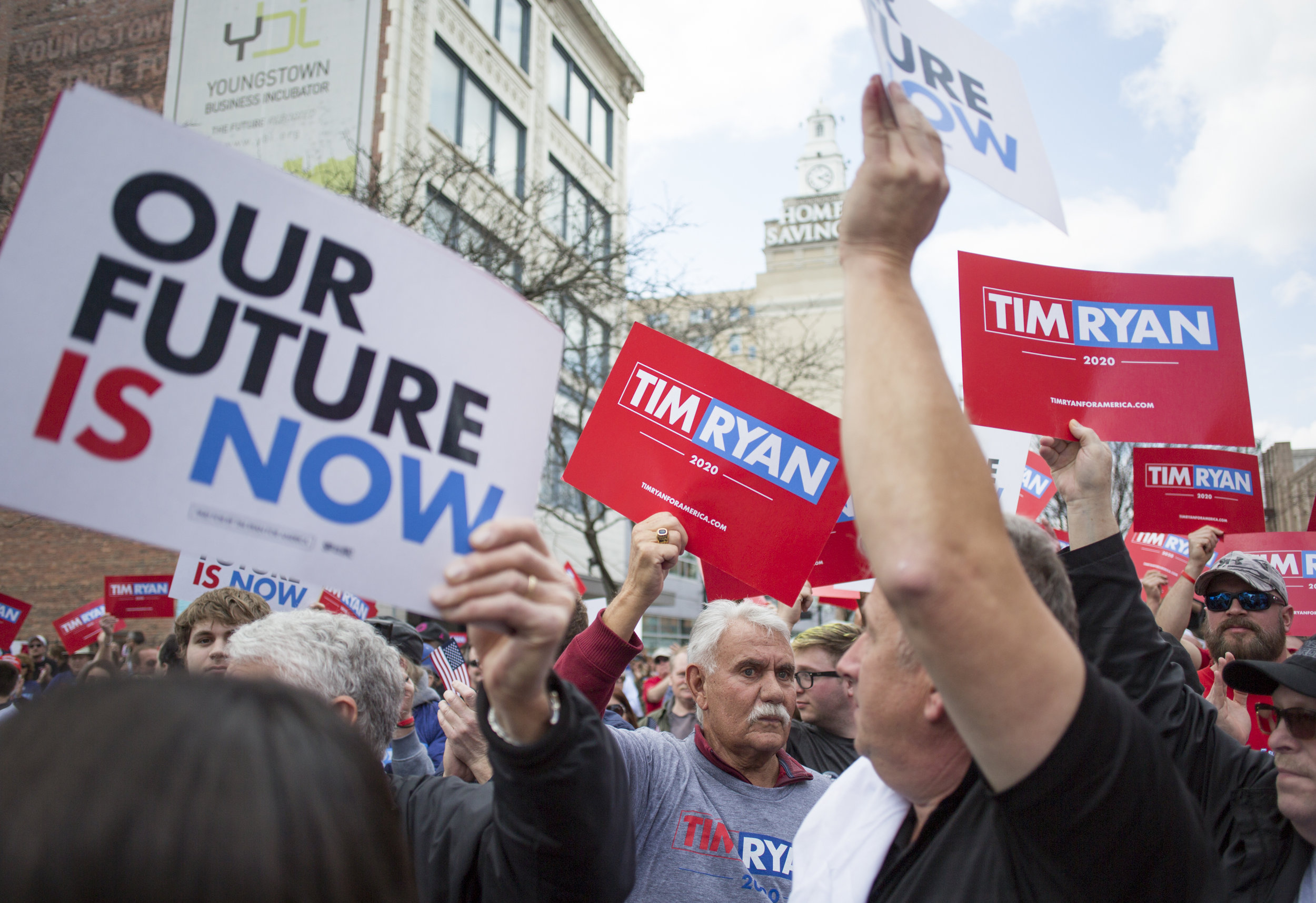  People in the crowd hold up campaign signs during Tim Ryan's presidential kickoff rally on Federal Street in downtown Youngstown, Ohio, on April 6, 2019. 