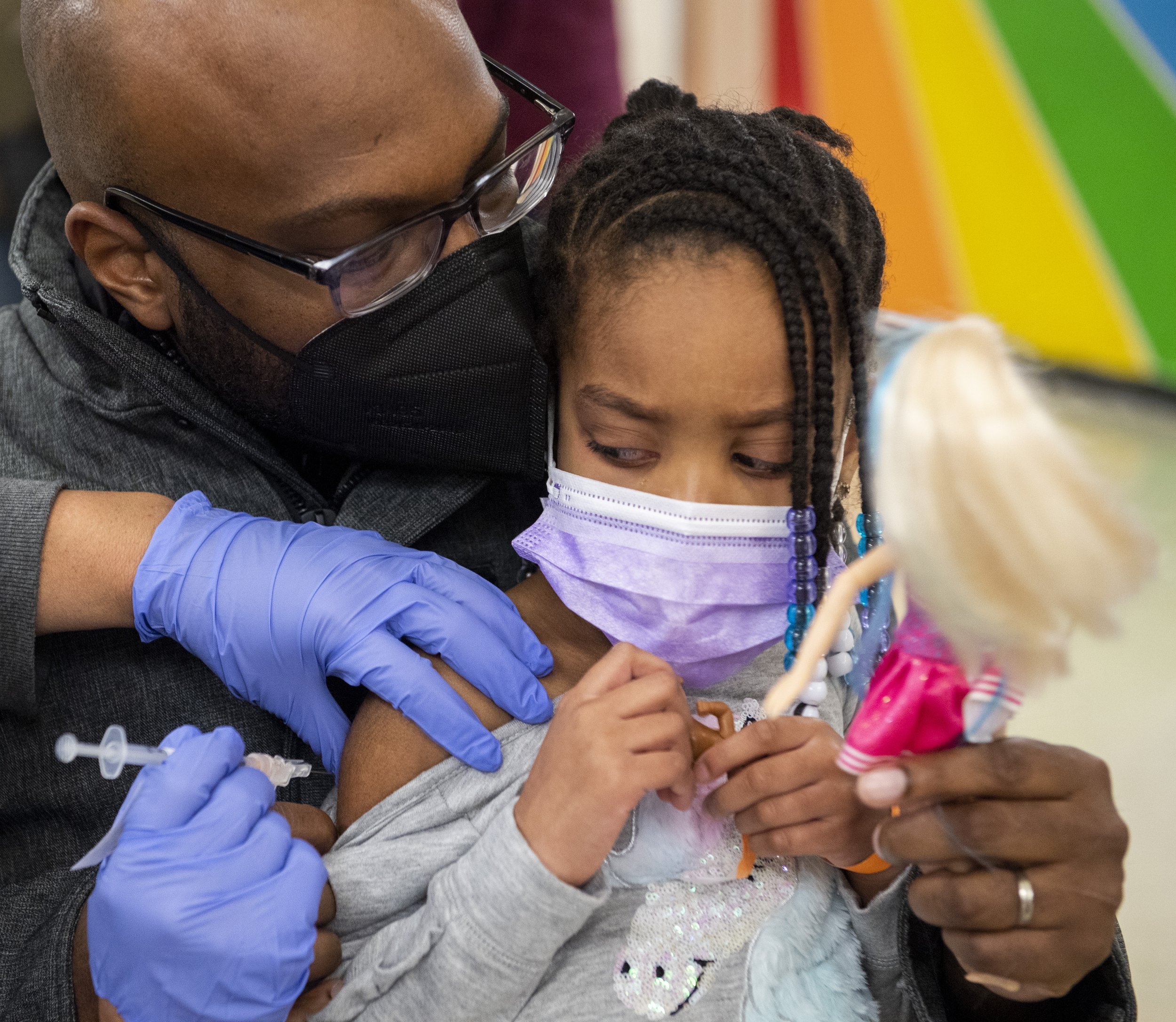  Ariyona Coleman, 5, of Crafton watches as she receives her first dose of the Pfizer vaccine from Lynne Oncea, a nurse with UPMC, while her father Antawn Coleman, also of Crafton, tries to distract her with a doll on Saturday, Jan. 8, 2022, in the ca