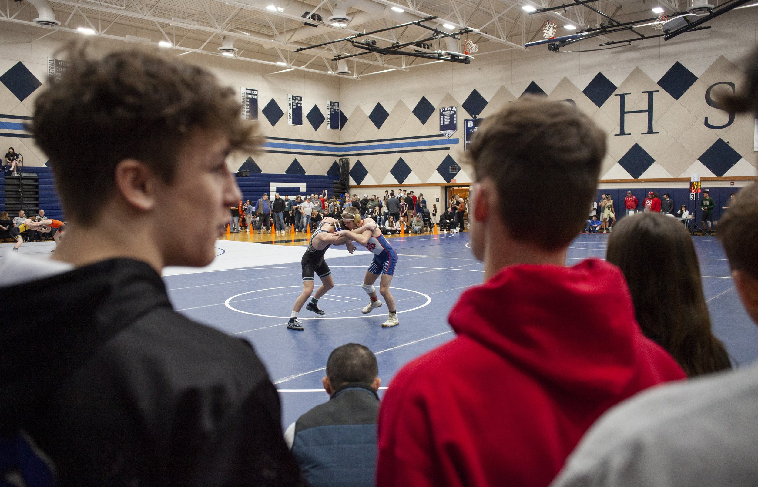  People watch as Burgettstown's Gaven Suica, left, and Mount Pleasant's Jamison Poklembo wrestle in the 133-pound championship on Saturday, Feb. 18, 2023, at Burgettstown High School. Poklembo won the match 3-1 in a sudden victory. (Emily Matthews/Pi