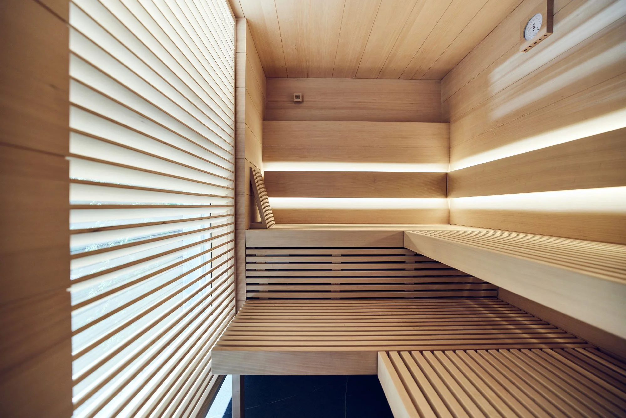 Innenraum einer modernen, hellen Sauna mit Holzverkleidung, Architekturfotografie Grünwald Villa