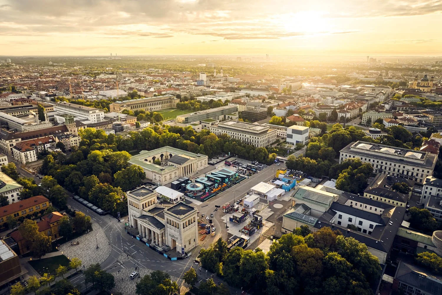 Luftaufnahme vonMünchen bei Sonnenaufgang mit Blick auf den Königsplatz, viele Bäume und historische Gebäude