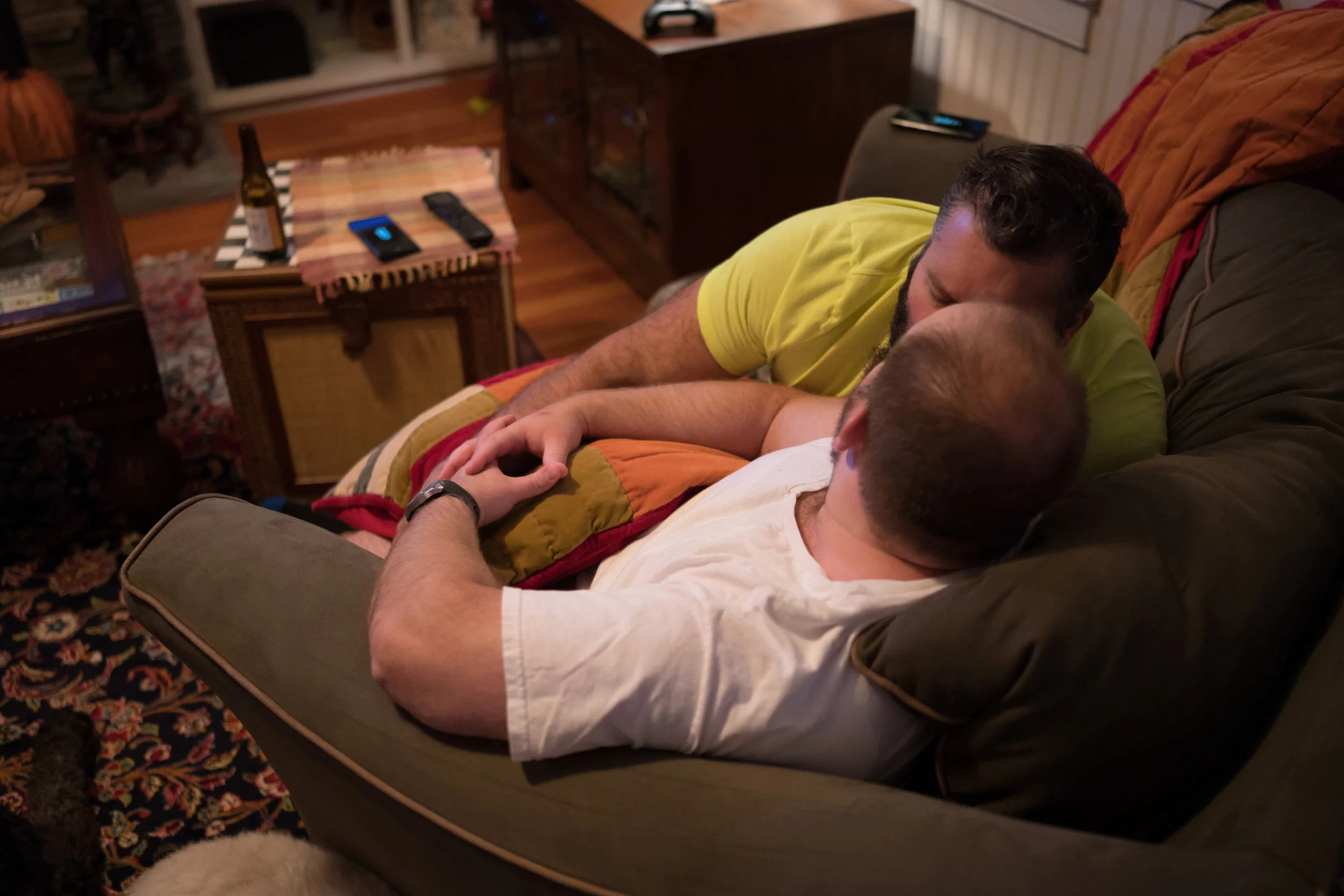 Thomas McCue and Sean Bresnahan share a quiet kiss in the living room of their home in Parish, N.Y. The two are kids at heart – watching suphero and old Disney movies is a common night in. Their three labradoodles Maxwell, Oliver and Jack are always at their sides.