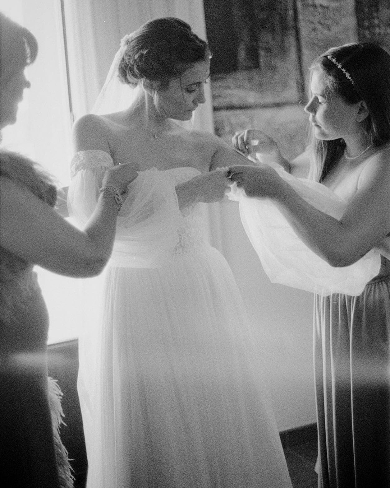 Elena's mother and sister were helping her put on the sleeves of her dress. When I checked the roll I shot in this room, I realized that light had entered the camera in some exposures, passing through some shots, and making them even more special.