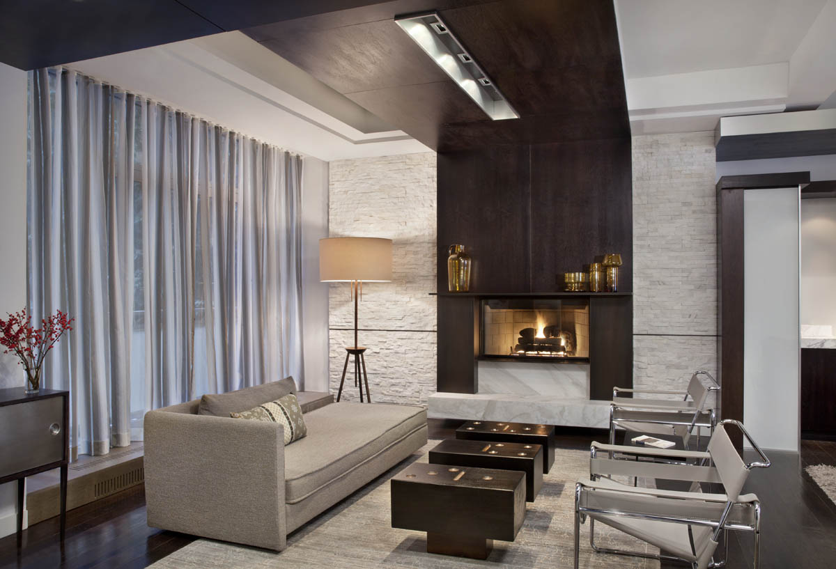 A seating area with a finished fireplace meets guests upon entry. A modern and inviting parlor.