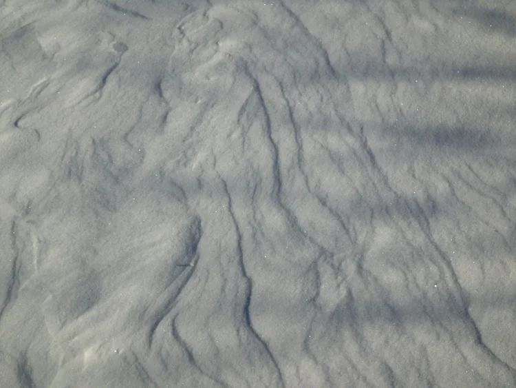Wind lines on a snowy hillside