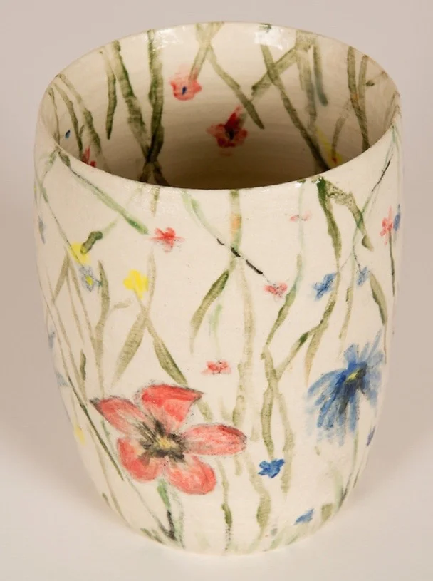 Flower bowl I created this bowl out of white clay on the wheel and then used different colors of underglaze to make the flowers and vines throughout.