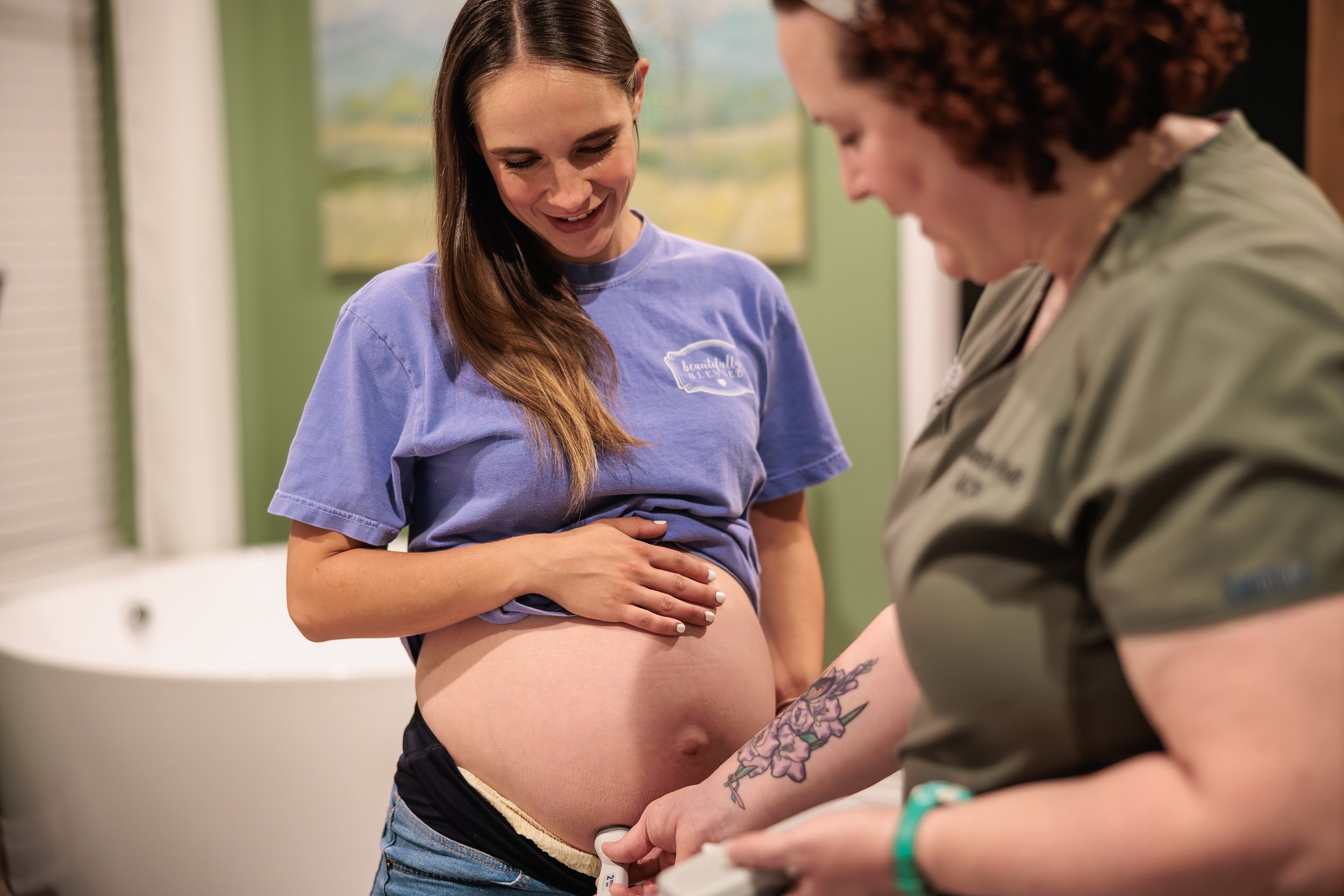 Midwife listening to the heartbeat of the baby on a pregnant mom in early labor at the Heritage Birth Center.