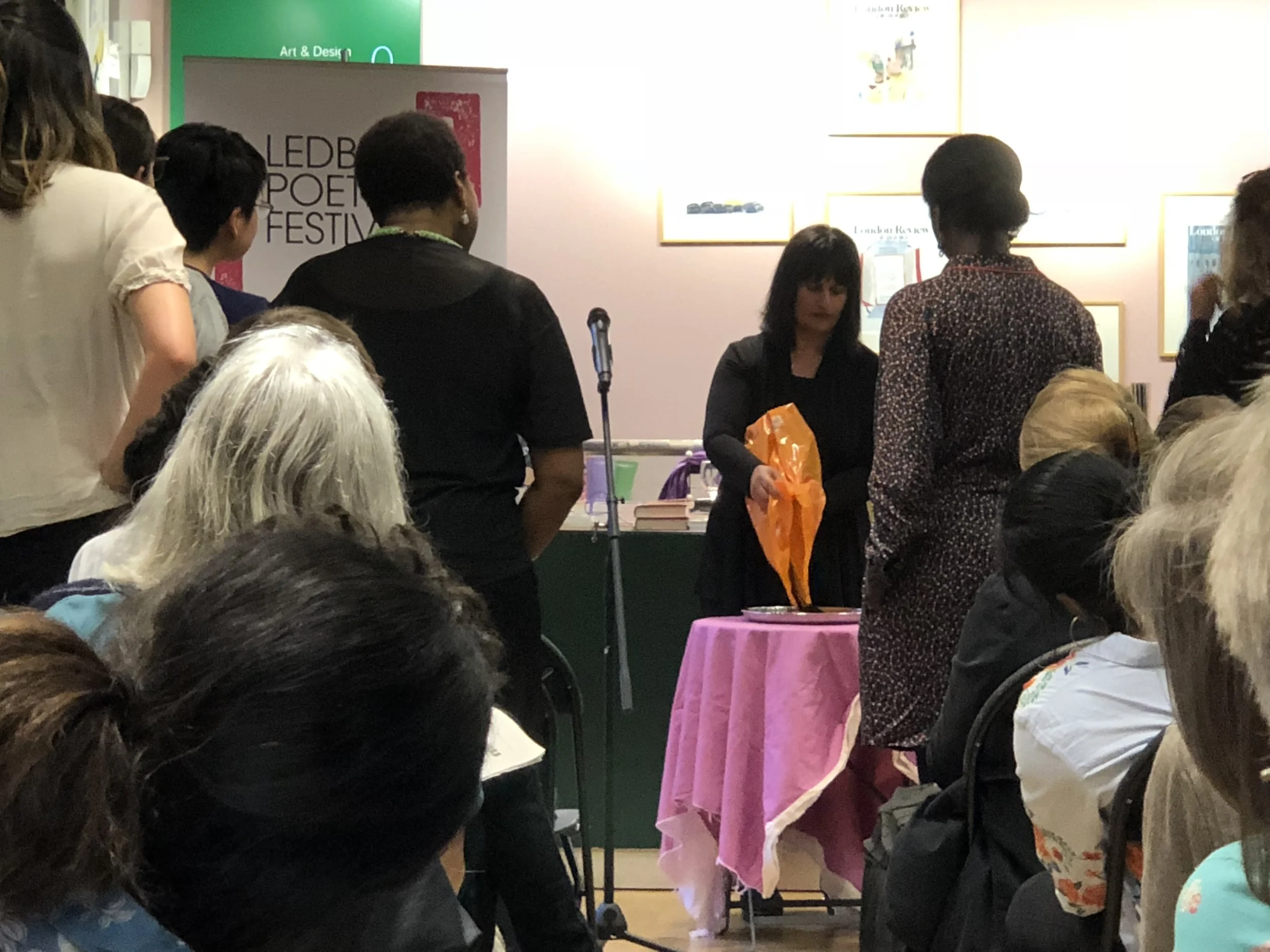 Audience members looking on at Bhanu and the shrine.