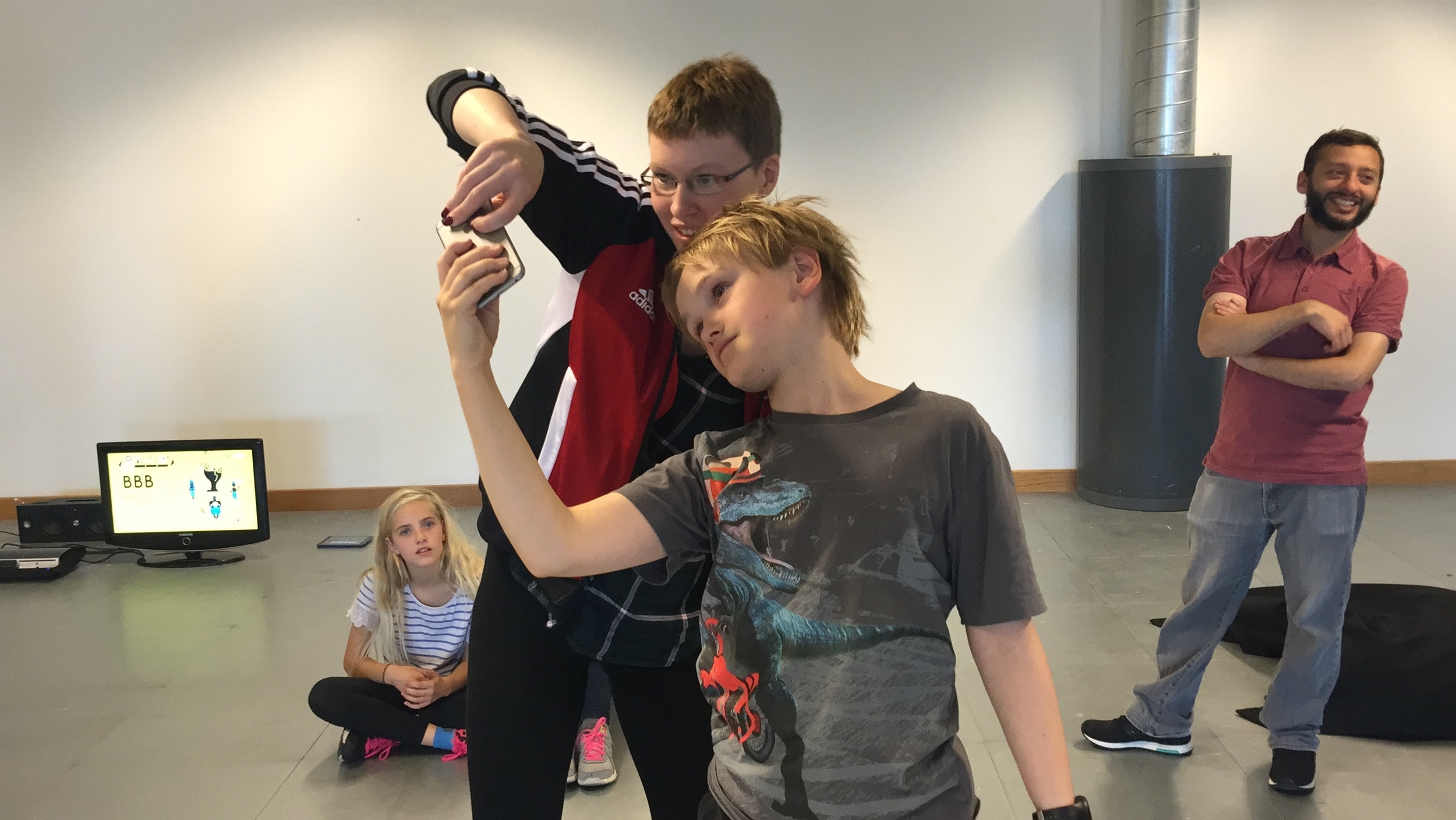 Some young participants taking part in a previous project. Here they are playing a digital game that requires you to move through the space whilst playing with a partner.