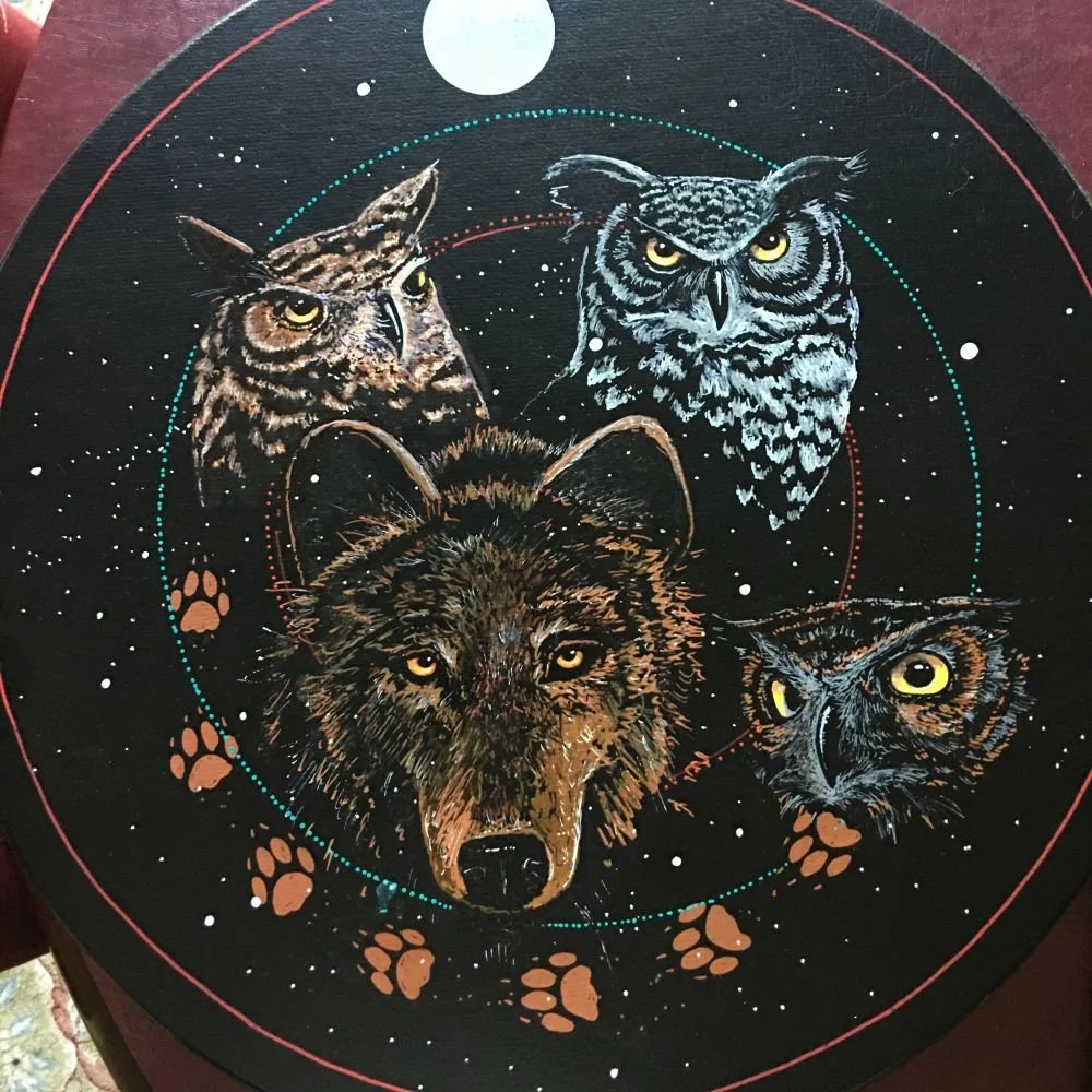 Strong Hearts medicine drum by David Craig, four owls and a wolf with paw prints on black