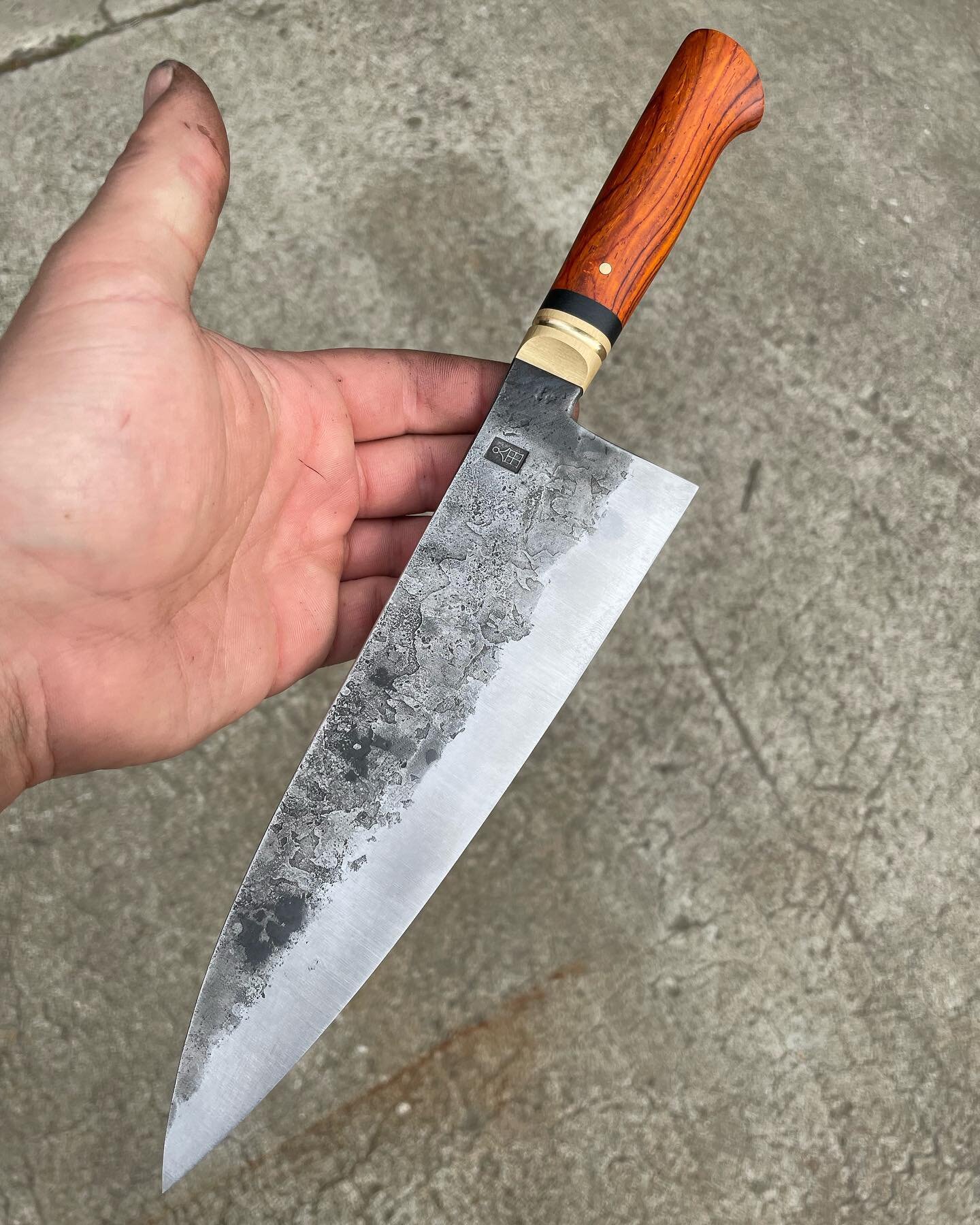 Recently sold 8&rdquo; hidden-tang chef with a more aggressive distal taper and solid brass bolster. 52100, and the other materials are black linen micarta and a rich cocobolo. 

#carbonsteel #chefsknife #handforged #forgedtotable