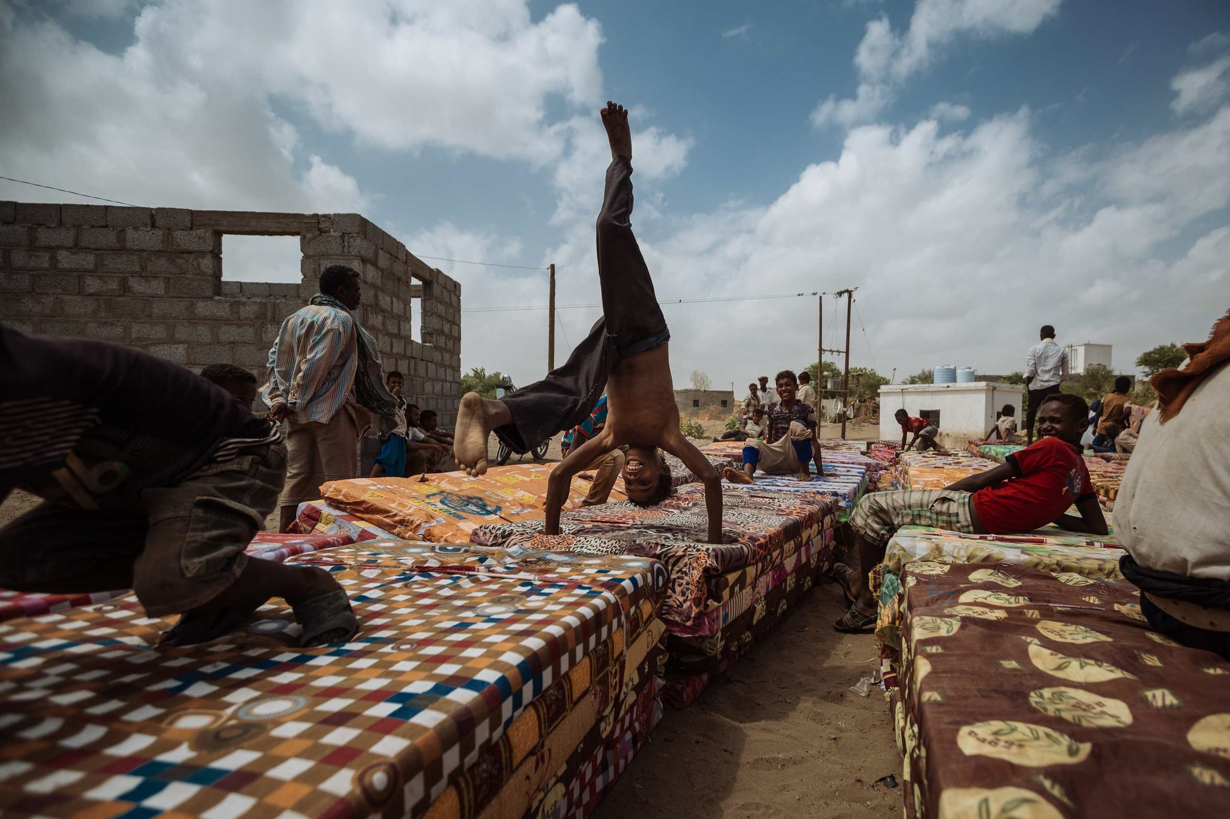 Children play with their newly received mattresses during a distribution of relief items in Lahij governorate, Yemen.