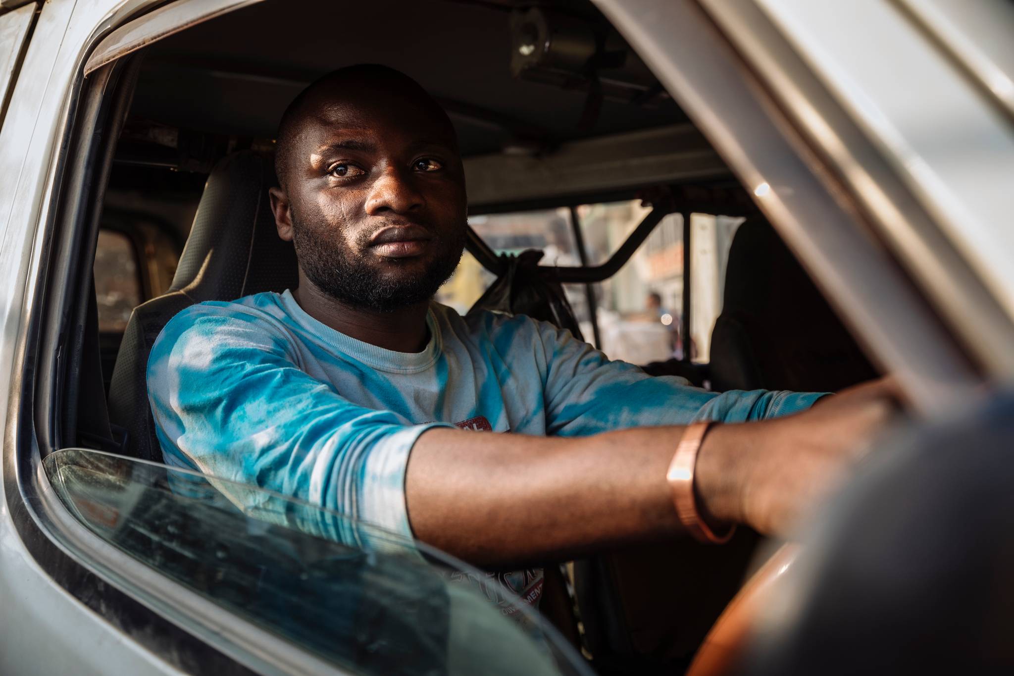 Bus driver Mumbere Sindani Olivier transports passengers along roads cutting through Ebola-affected areas of the DRC. He is trained to detect symptoms of Ebola among passengers, encouraging them to wash their hands to prevent the spread of the disea