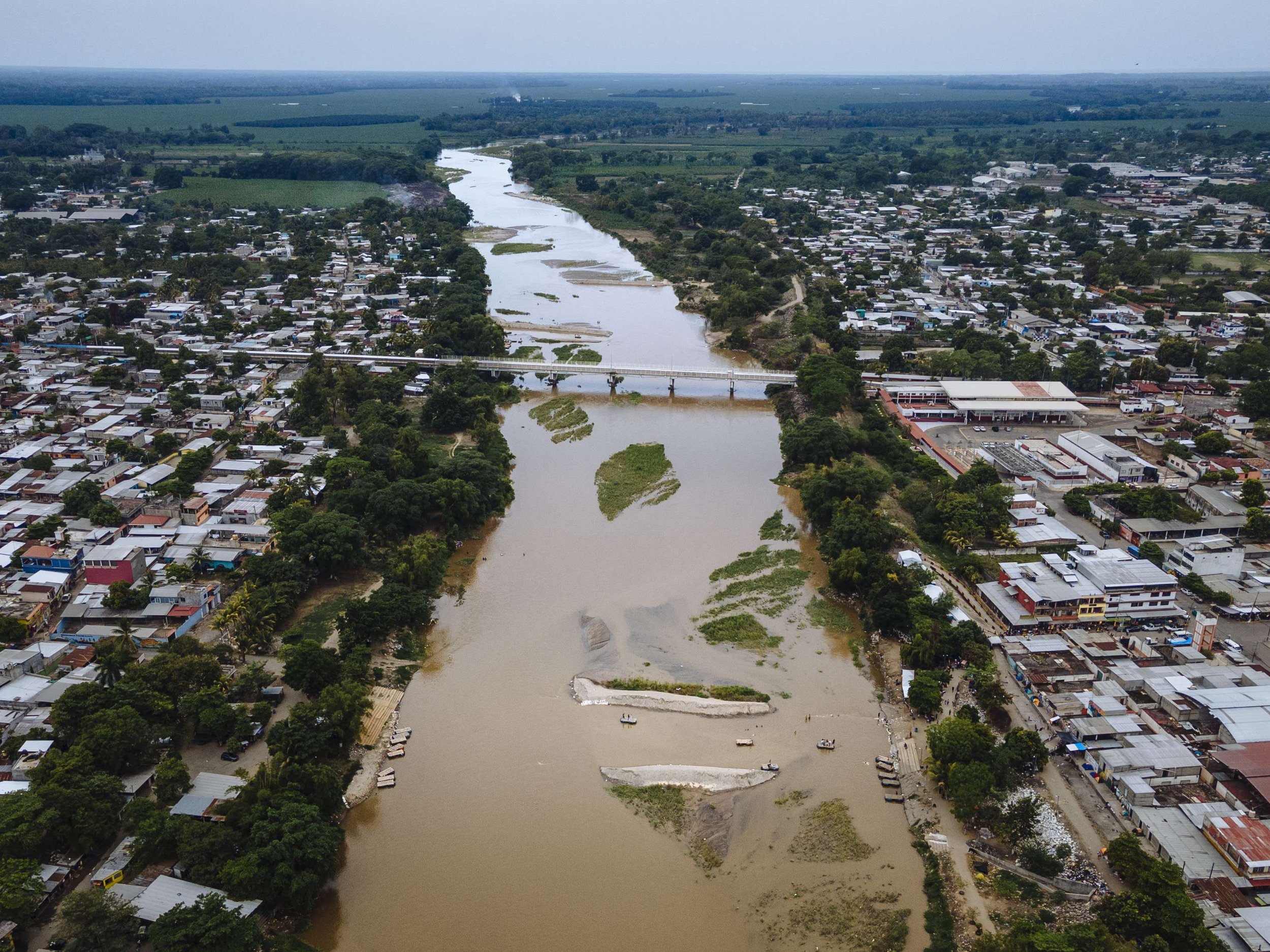 Smuggling boats can be seen ferrying migrants across the Suchiate river next to the Puente Rodolfo Roble, the official border crossing between Guatemala and Mexico.