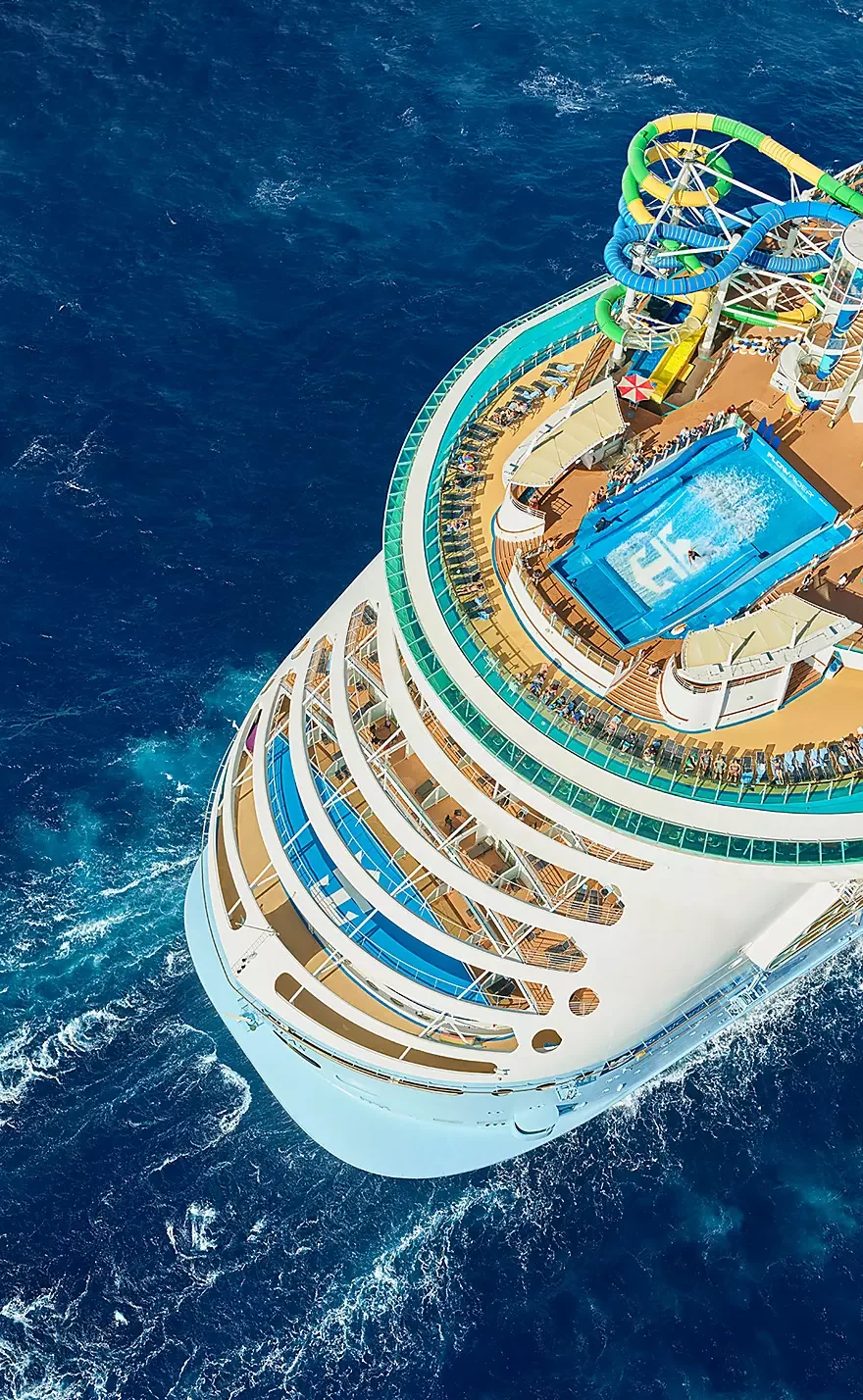 Aerial view of a cruise ship with a water slide and swimming pool on deck.