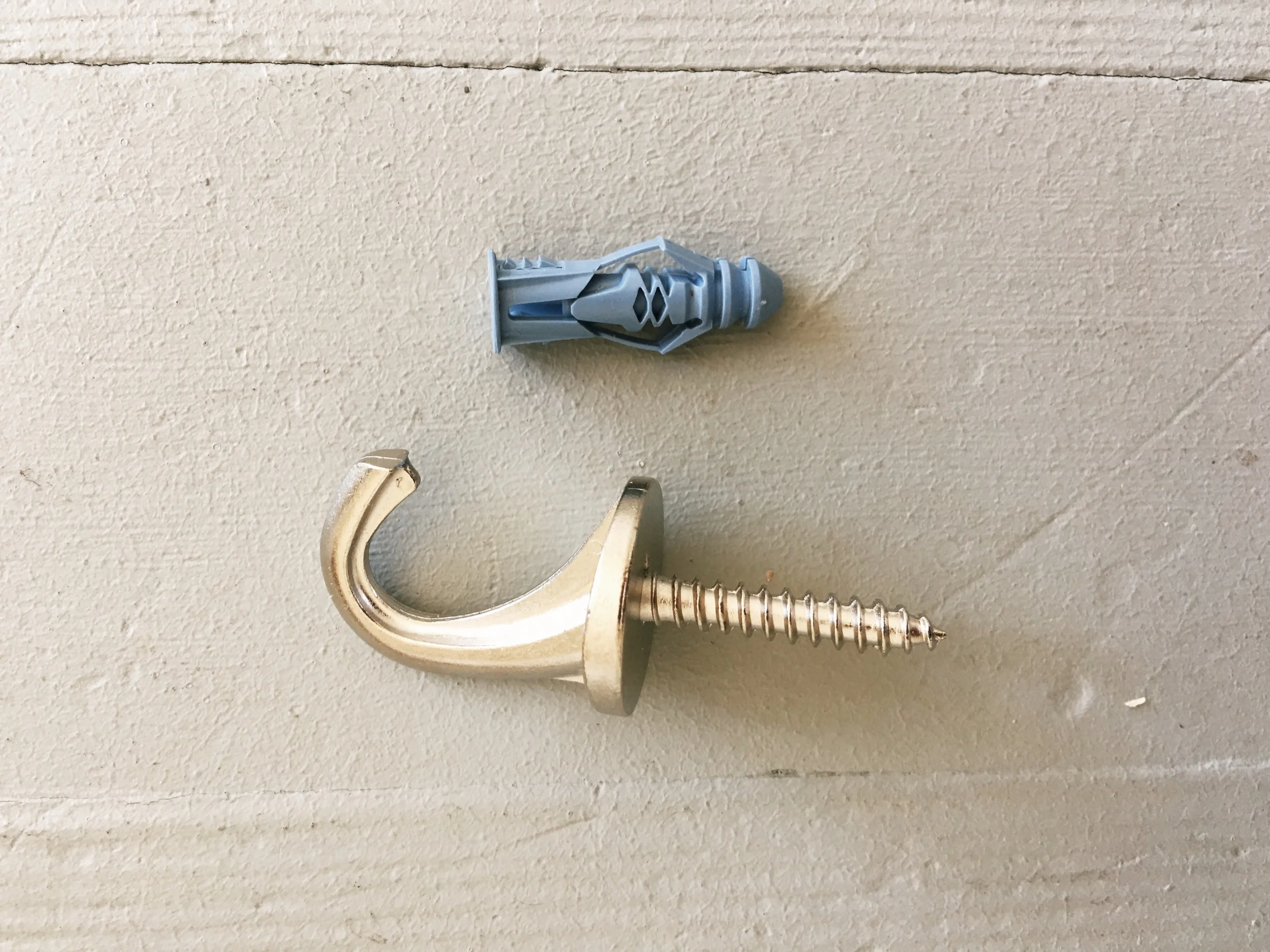 STEP 6: Drill a hole into your ceiling, then take your ceiling hook (It comes in a pack of 2 at Home Depot) and push the plastic piece into the wall first as this will be the grip for the actual hook. Once the plastic piece is in, start to screw in the hook till its fastened tight.