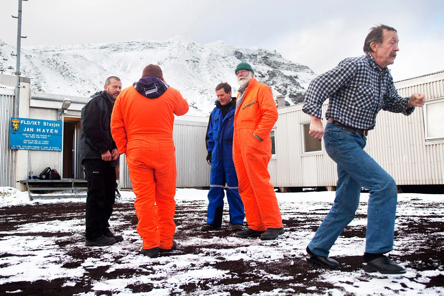 Arbeiderer som jobber 6 måneder til 1 år av gangen på Jan Mayen står utenfor noen brakker i Olonkin City.