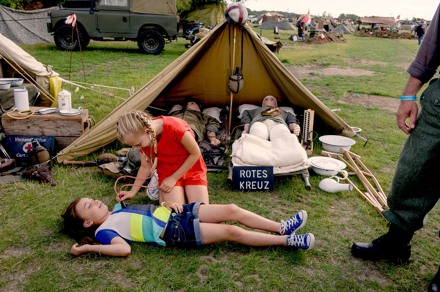 Girls playing in front of a display of a German field hospital tent. Re-enactment event in Essex