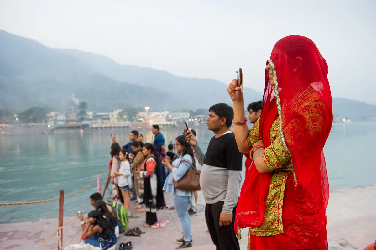 young woman filming The Artti ceremony in Rishikesh, 2019