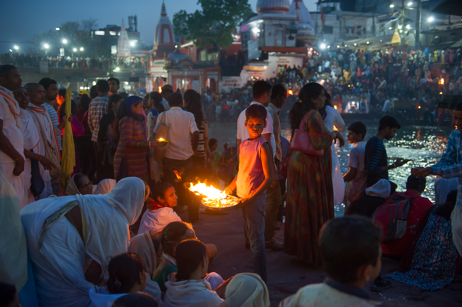  Boy collecting donations following Artti ceremony, Haridwar, 2019 