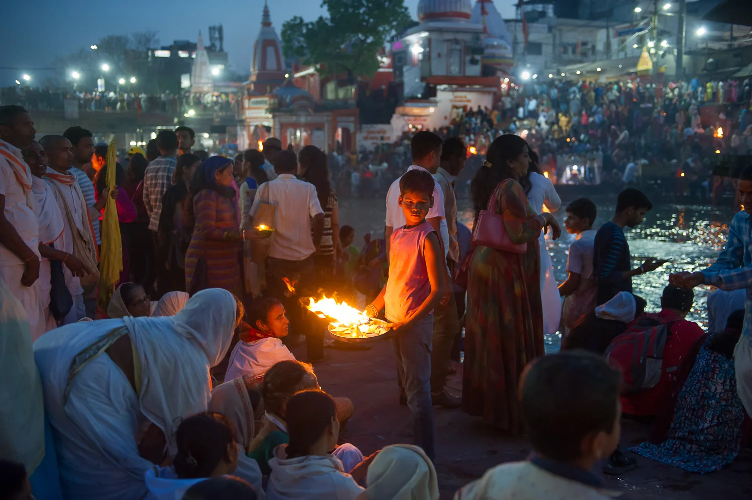 Boy collecting donations following Artti ceremony, Haridwar, 2019