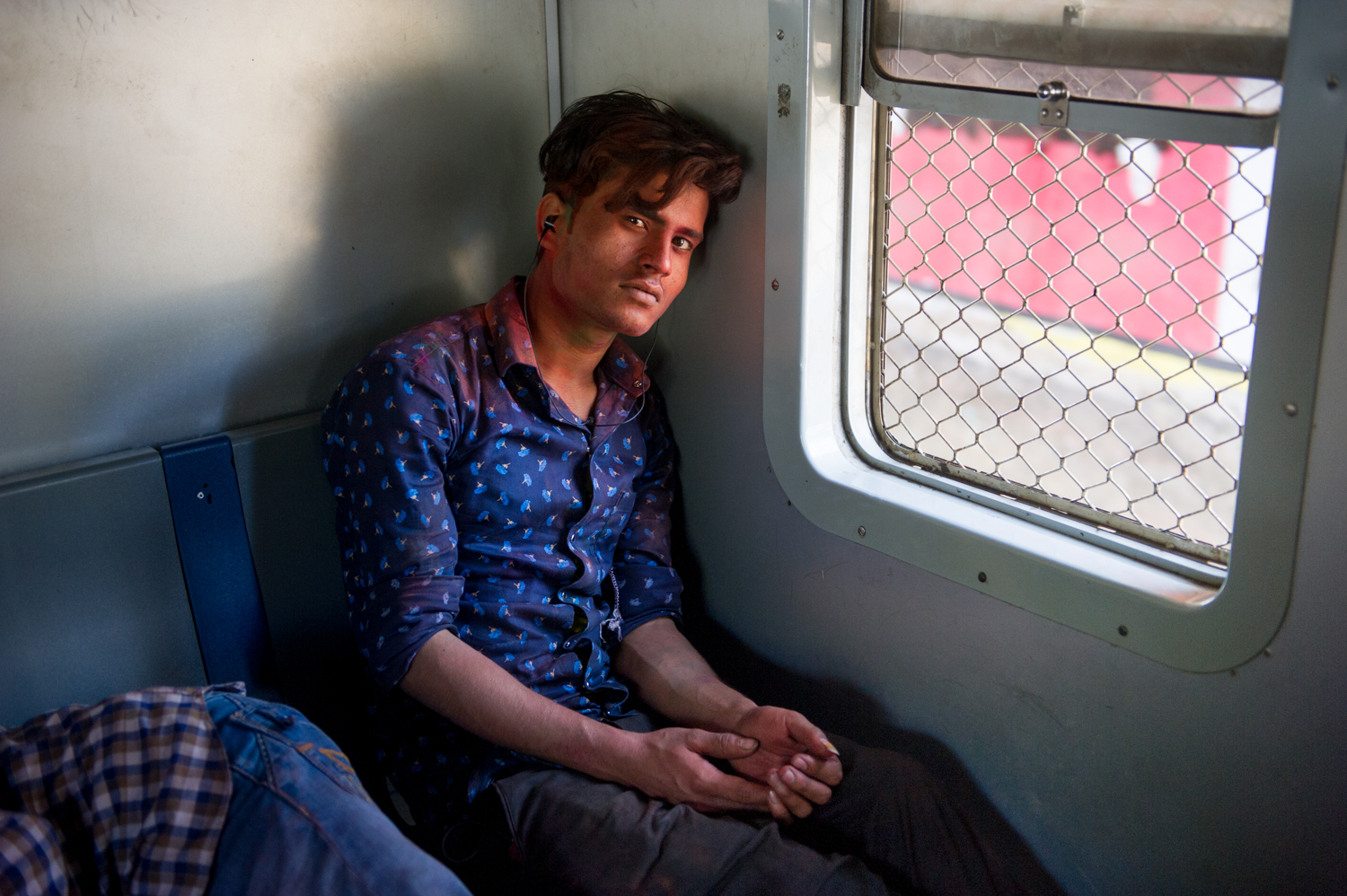  Young man travelling on a local train following The annual celebration of Holi, Mumbai, 2019 