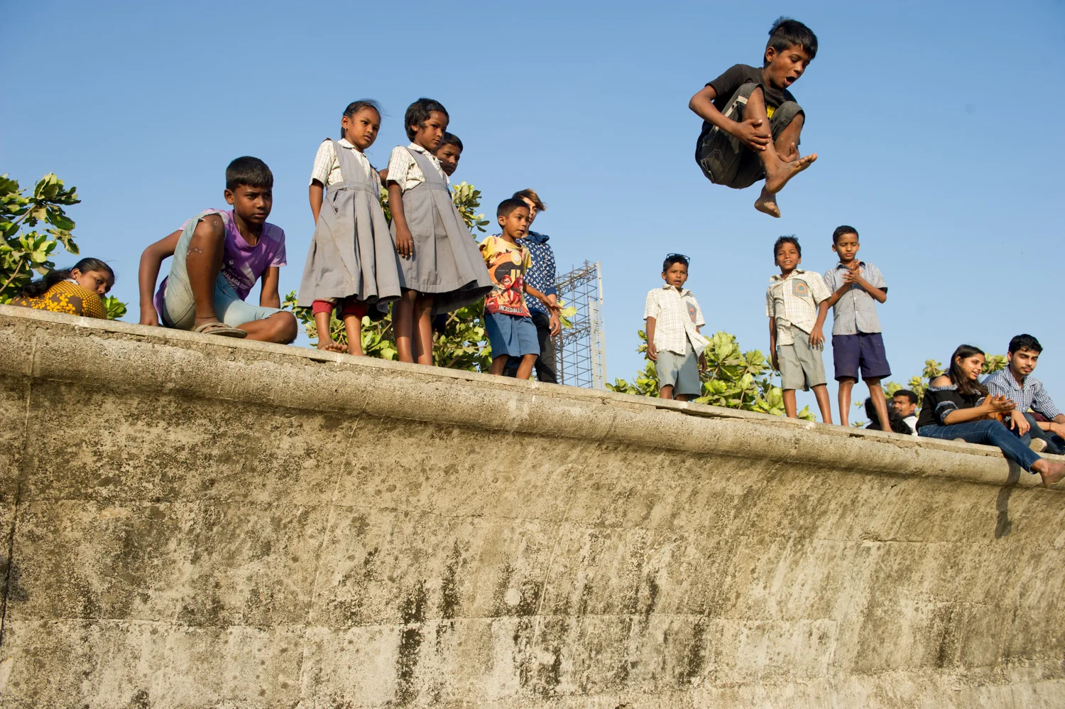 Children jumping off Boardwalk onto the Beach, Mumbai 2019