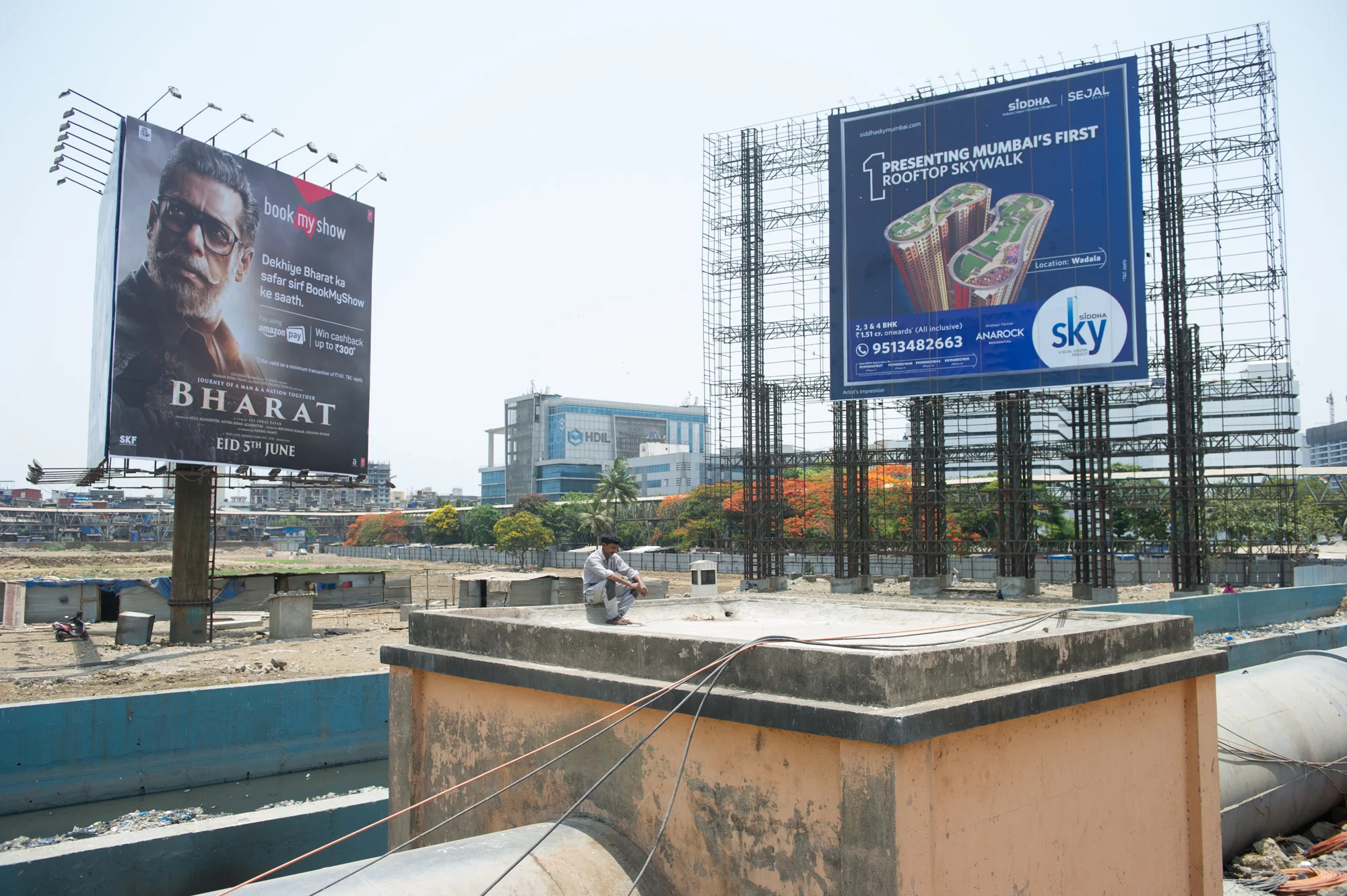 Advertising billboards, Dharavi slum in the background, Mumbai, 2019