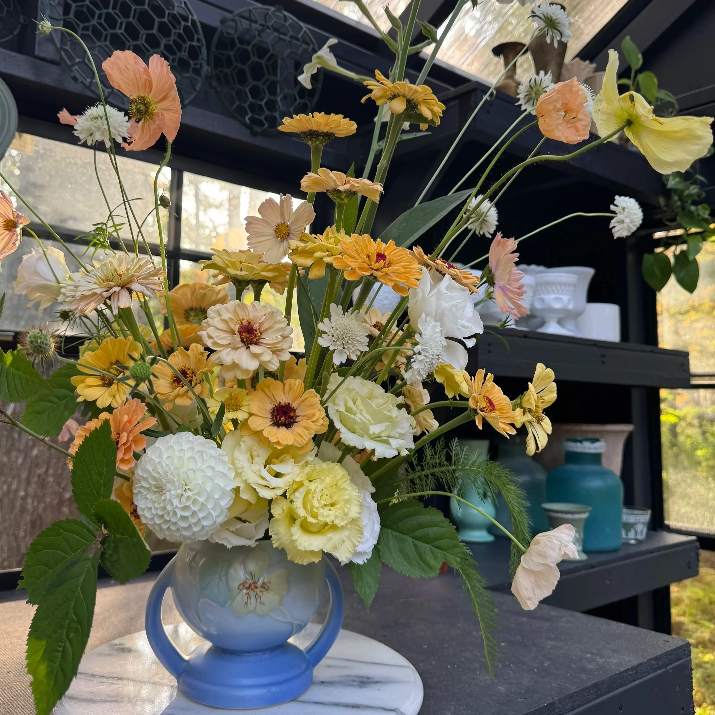 Warm zinnias, dahlias, lisianthus in a blue vase.jpg