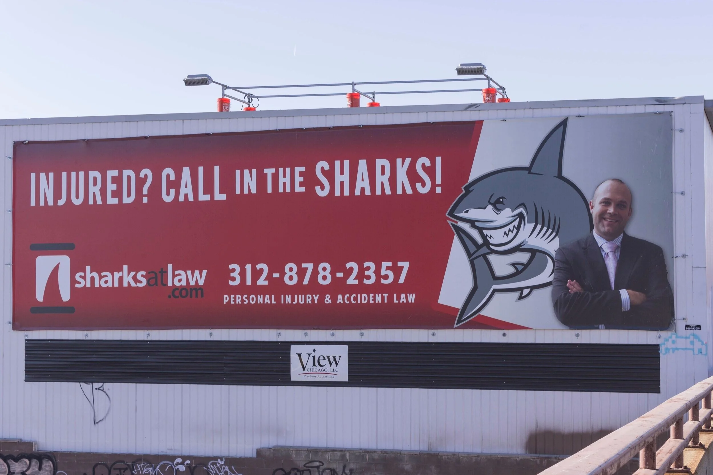 Sharks Law billboard campaign using bold attorney branding and phone number recall for personal injury advertising