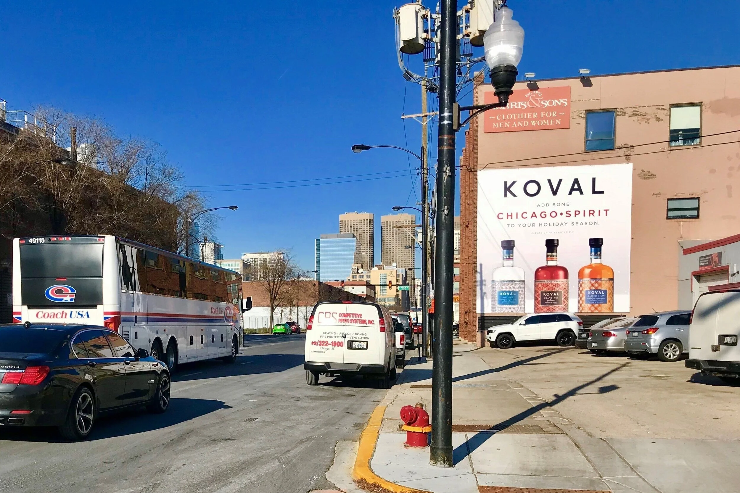 Small business billboard advertising for Koval Distillery reaching drivers and pedestrians in a city neighborhood