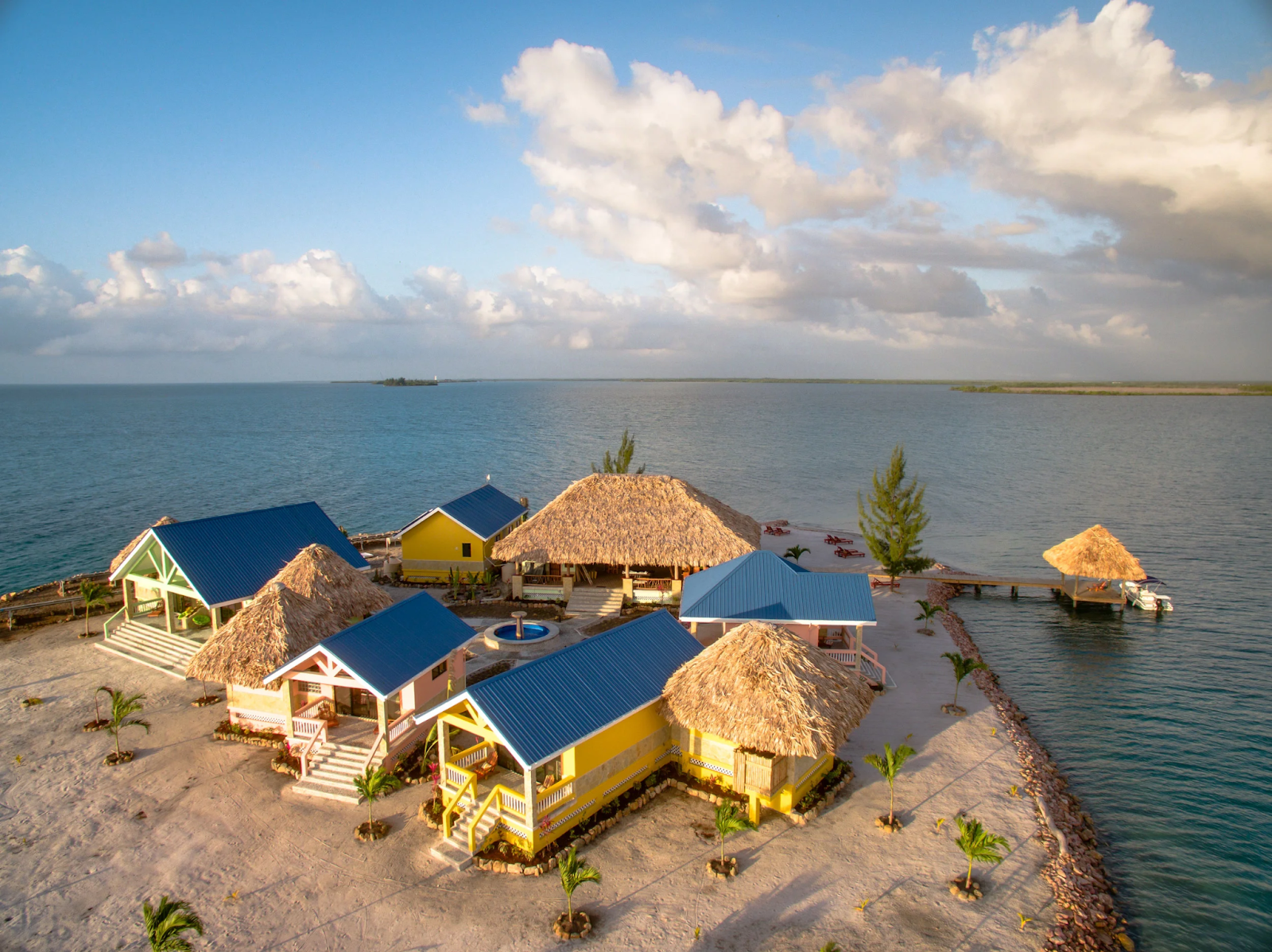 A collection of colorful rooms and cabanas on the beach of Little Harvest Caye