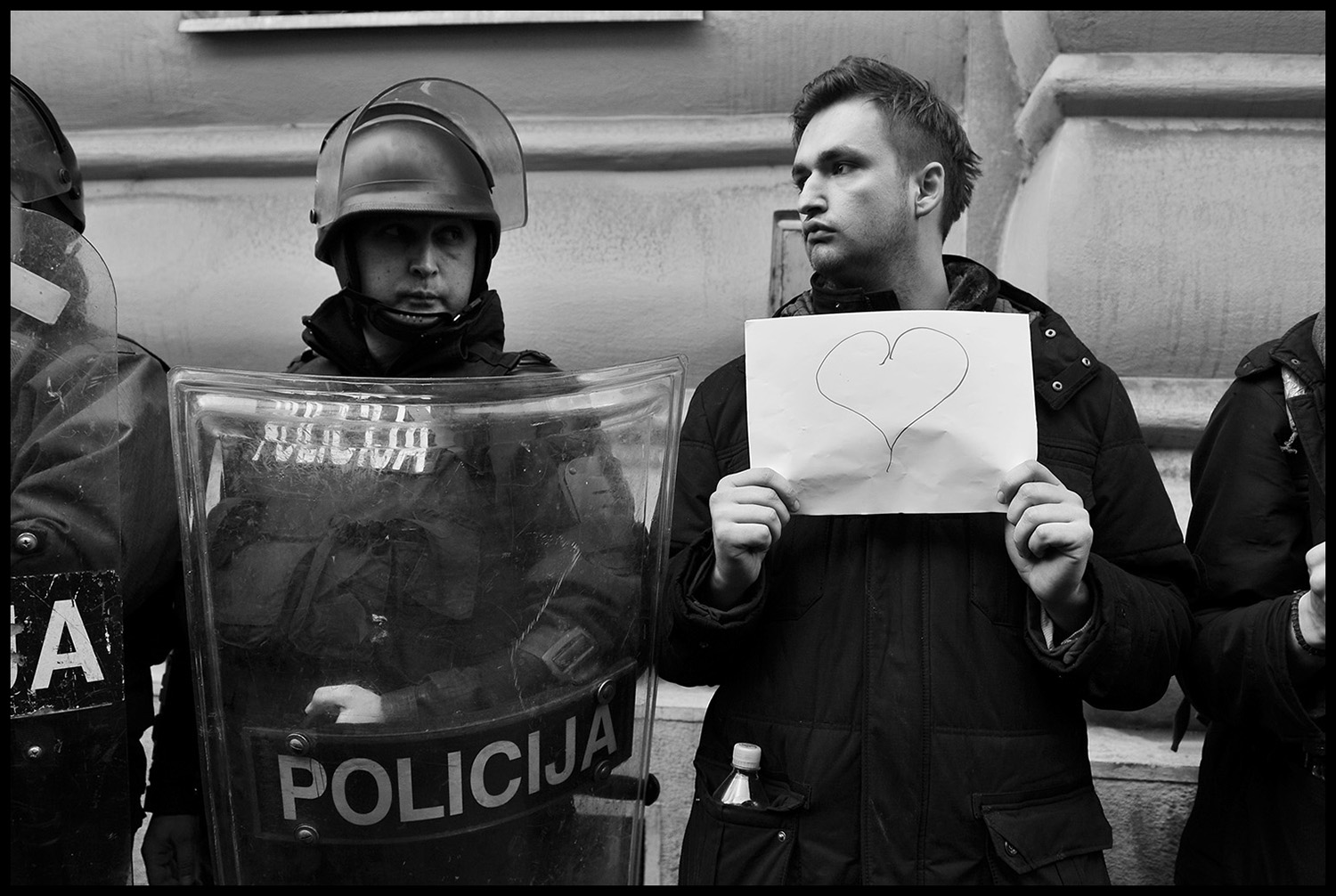 Bosnian young man standing next to a policeman and holds a banner with drawn heart during protest for the release of ten protesters in front of the Prosectors Office Building in Sarajevo. Several hundred people continued to protest in Sarajevo, demanding from politicians of all levels of government to resign. Street protests that erupted on February 7, a number of government buildings in several towns were ransacked and torched, while hundreds protestors and policemen were injured in scuffles.