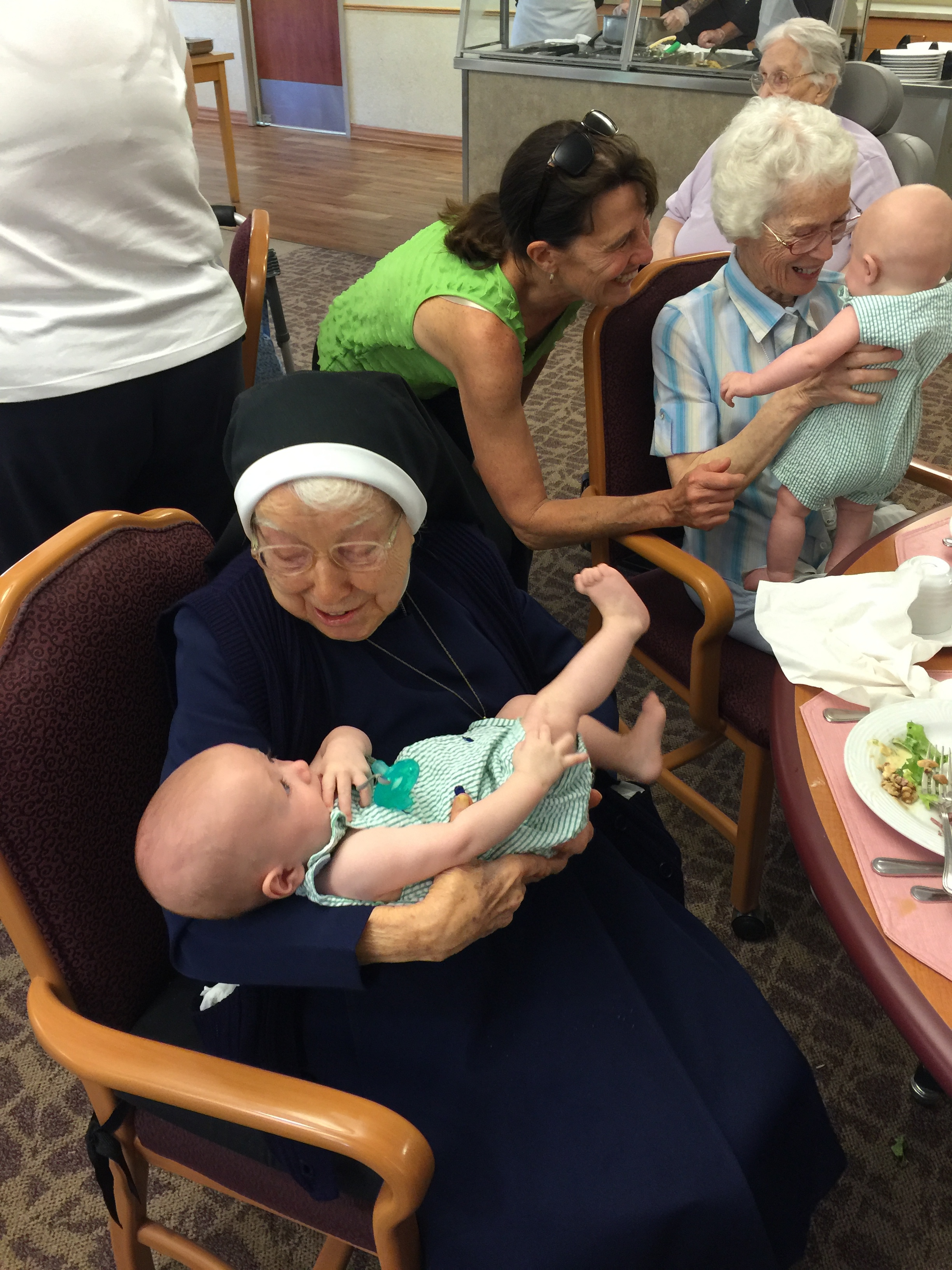 This is Sister Romaine Krug holding baby Charlie - she is 102 years old, the 3rd of 15 children and was a "baby nurse" prior to being a nun. She said in all of her years working with babies she had never met quadruplets. She also called Charlie a pistol...spot on!