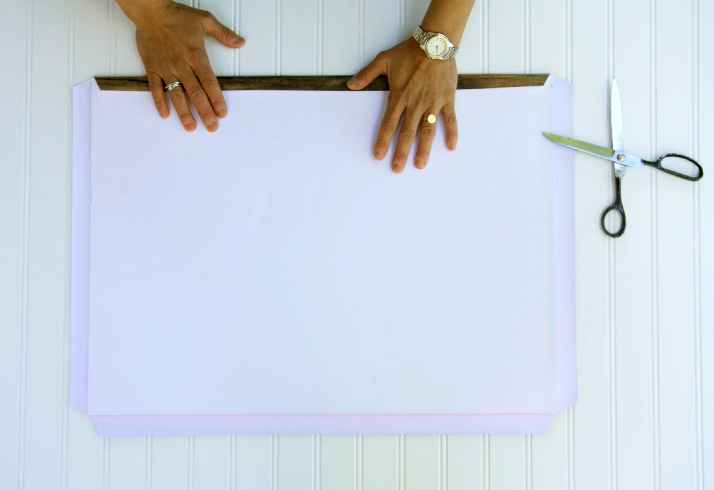 Tape down one side at a time, flattening as you go to get rid of any bubbles.