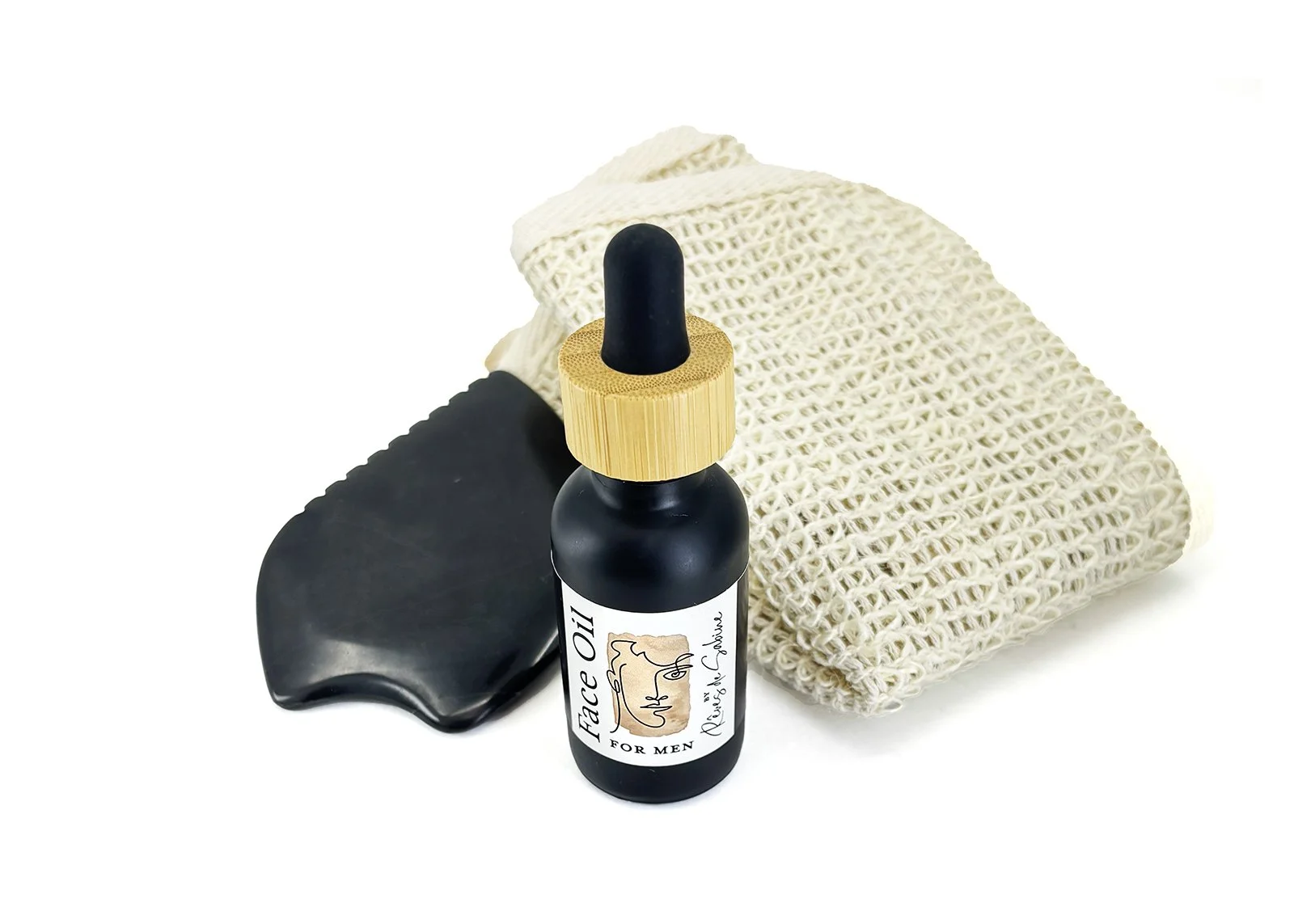 Men’s grooming kit with Reves de Sabine face oil, Bian stone gua sha, and exfoliating cloth.