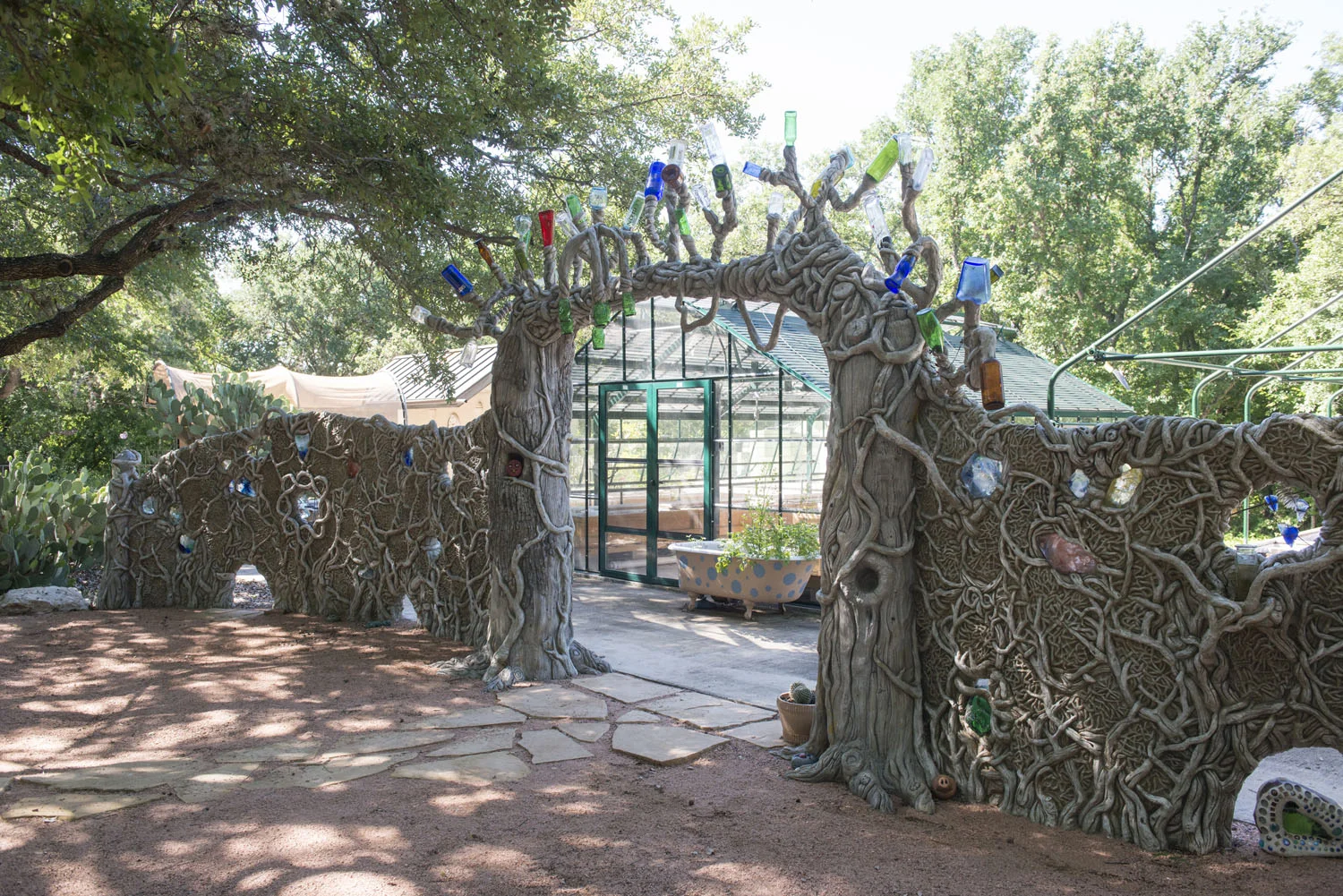 Portion of a hand carved vertical concrete faux bois wall with glass, copper and upcycled bottles. (photo by Kemp Davis)