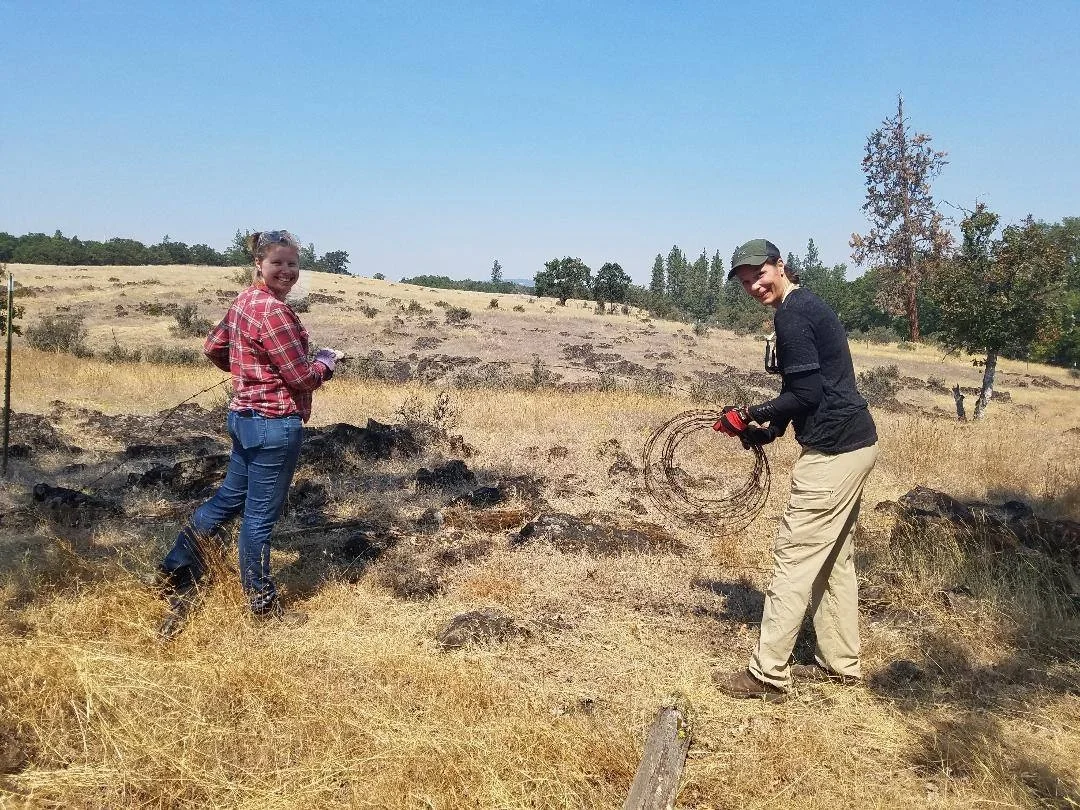 Emily Olsen (left) and volunteer Annette Small helped to remove barbed wire fencing for safer wildlife passage at Rogue River Preserve.