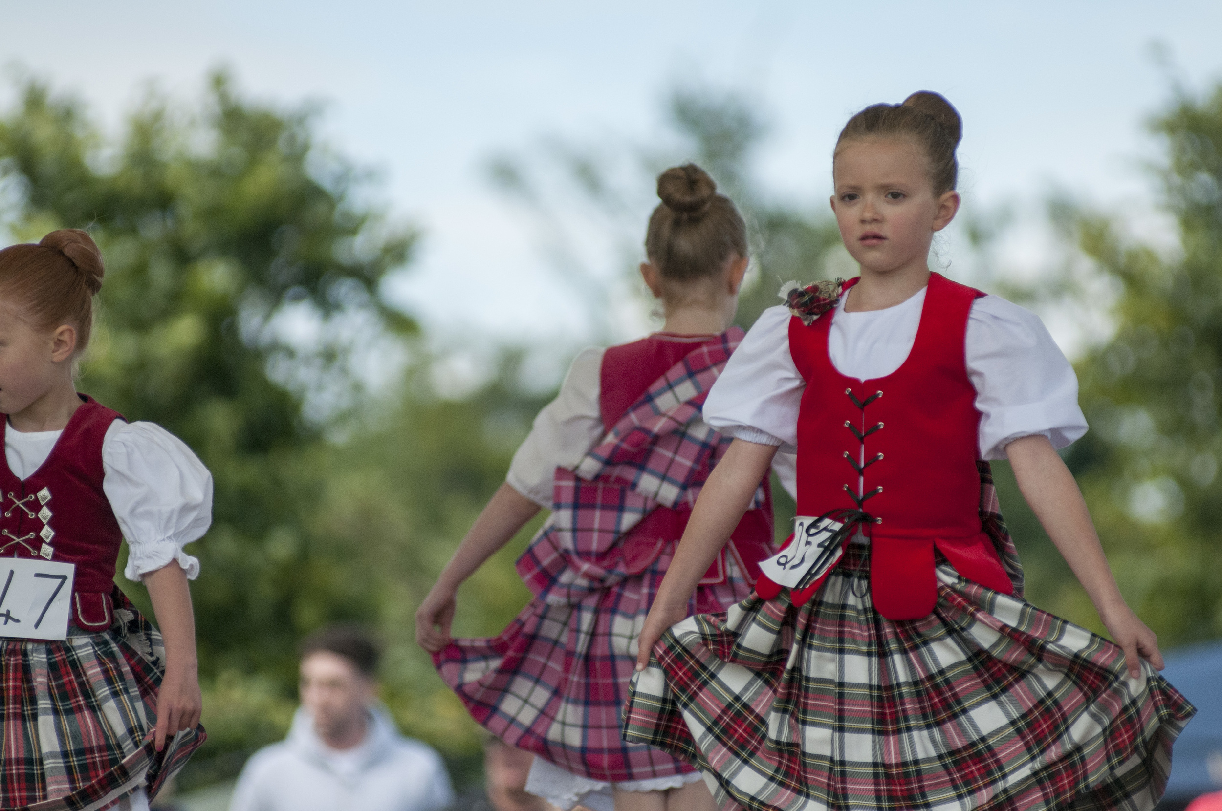 Scottish dancers perform a traditional dance in front of a table of judges at the St. Andrews Highland Games on July 26, 2015. 