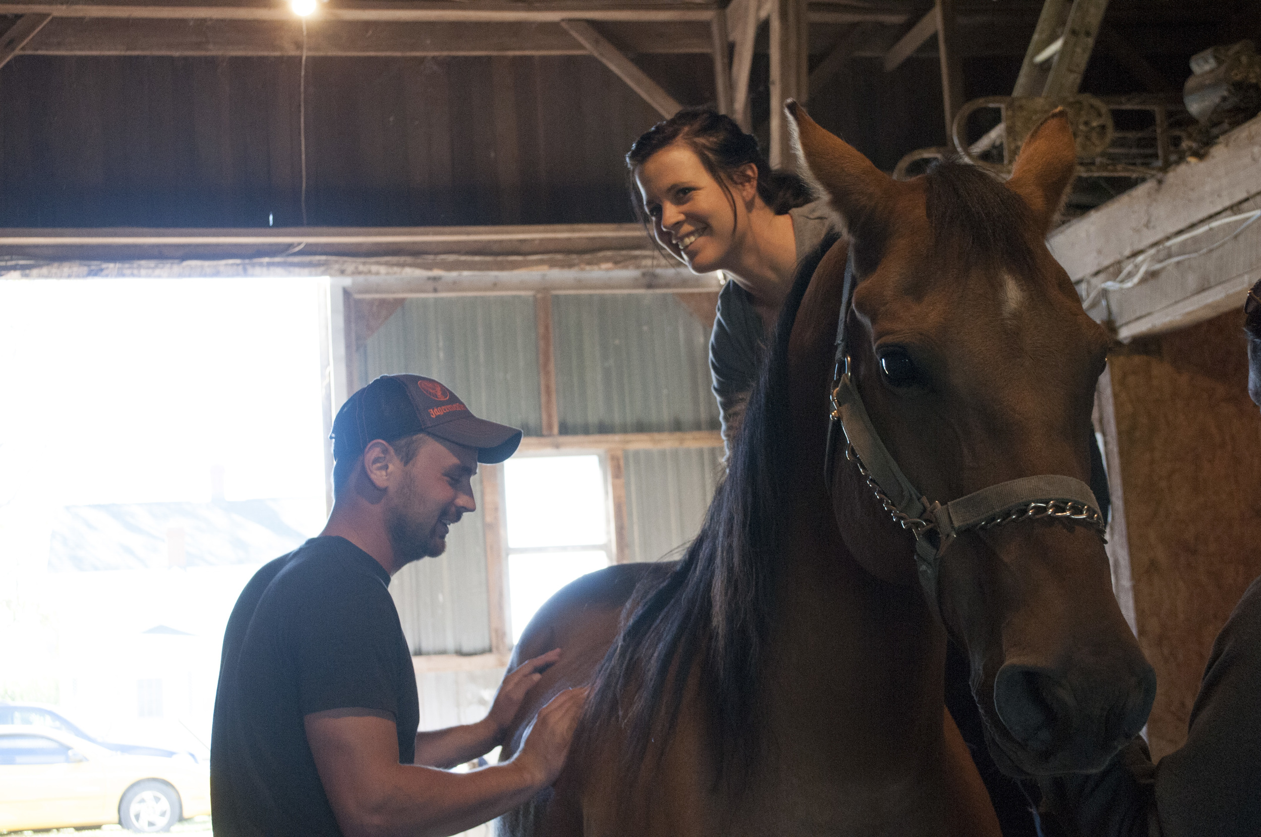 Garrett Davis, left, and Deanna Milhoan laugh after Richardson’s horse, Switch, whinnied with happiness after having its back cracked. Milhoan said, “I could feel all of his tension just relax after his back was cracked, I bet that felt great!” (Sep