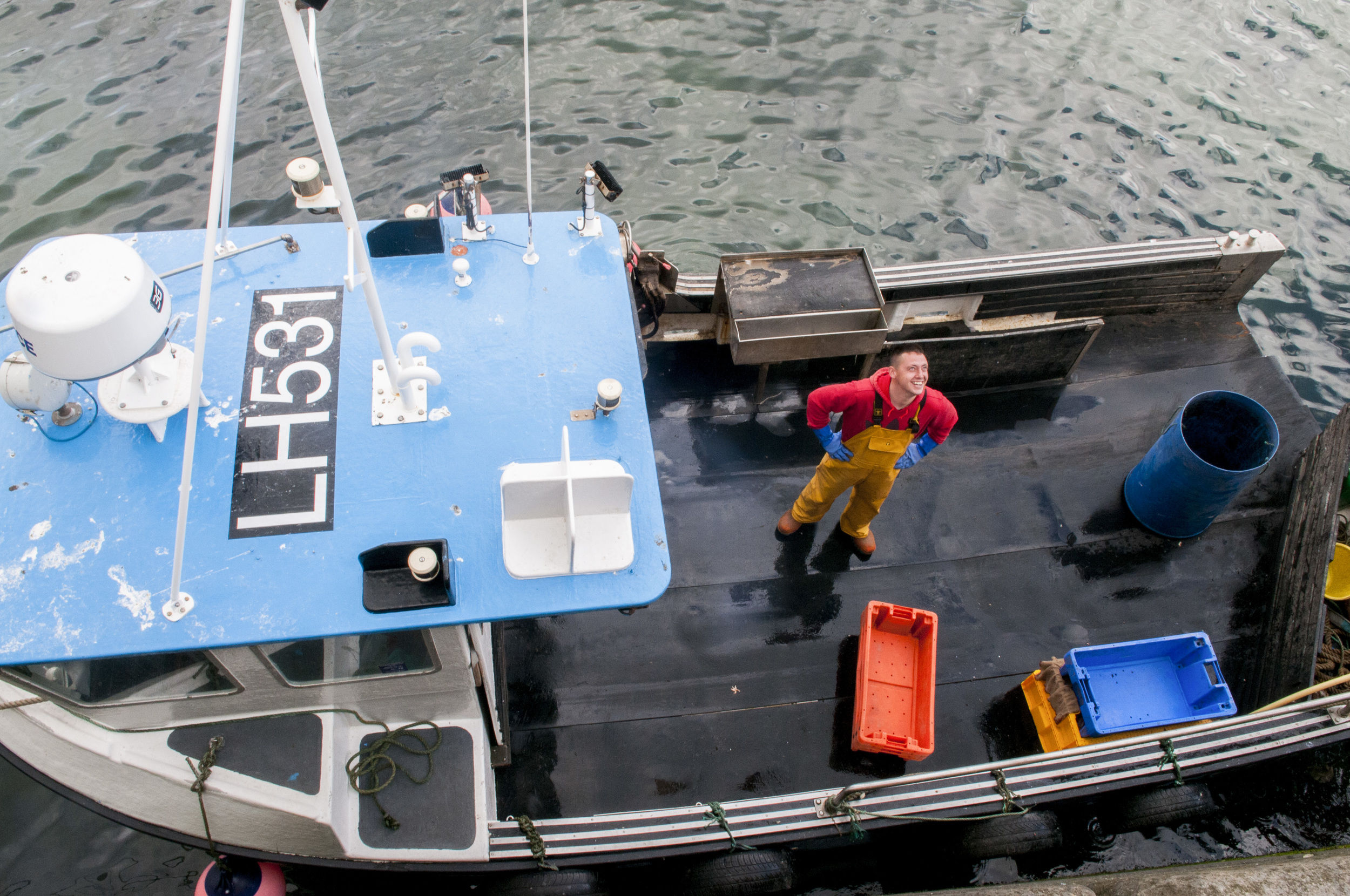 Sean Fraser looks up from the deck of the "Charlie Boy" after unloading the day's catch of lobster onto land in Dunbar, Scotland on July 23, 2015. 
