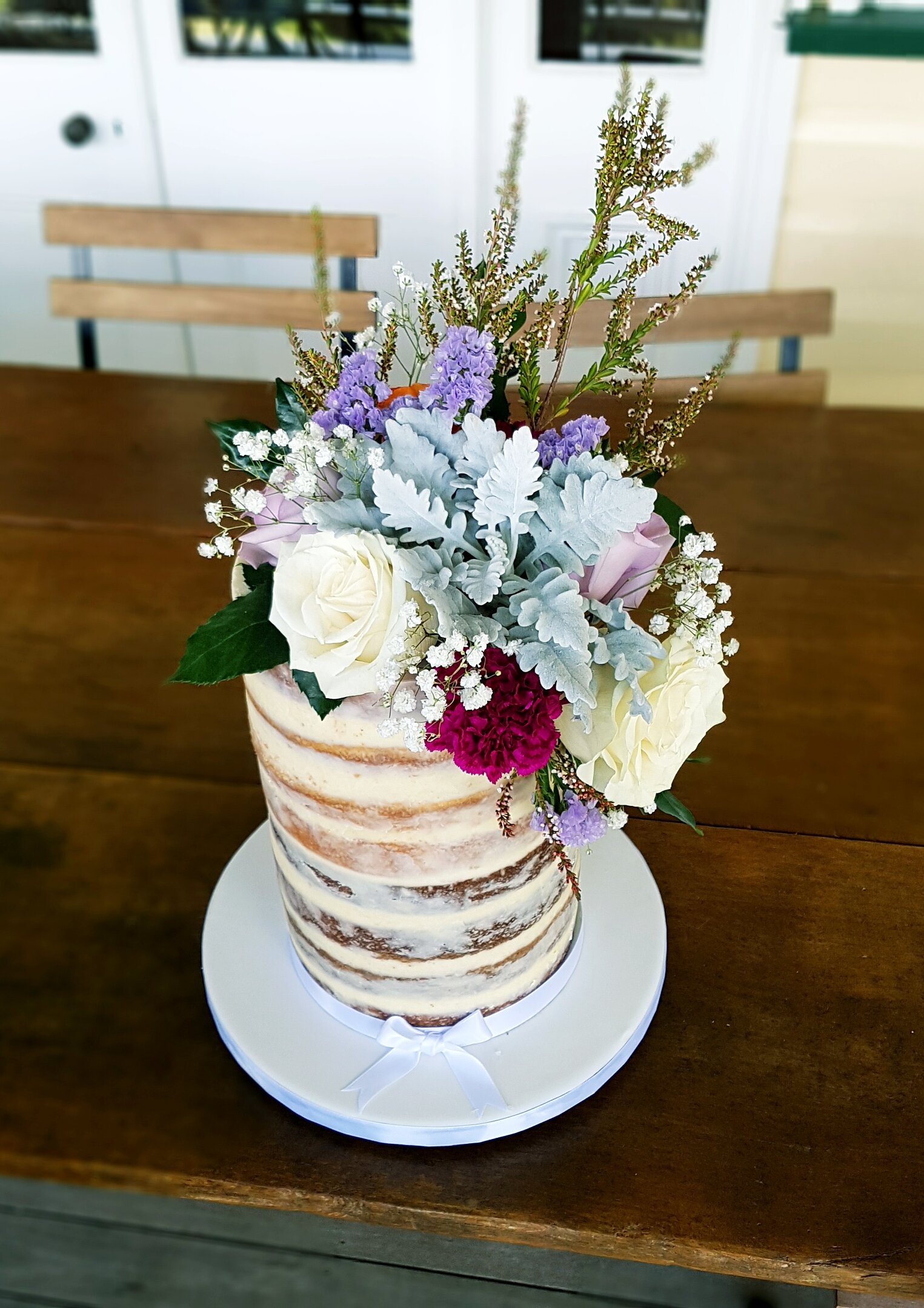 tall semi naked wedding cake fresh florals