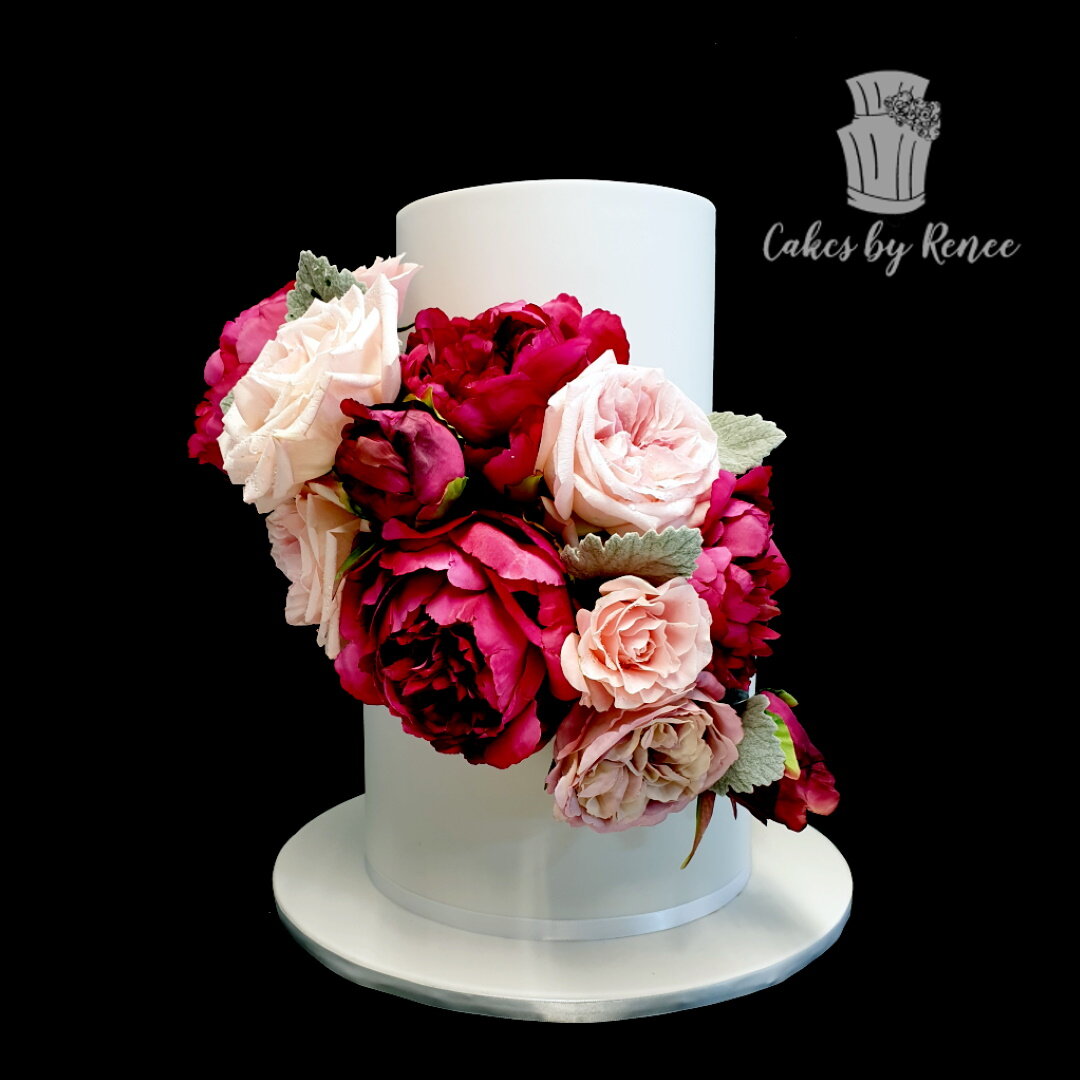 2 tier white wedding cake lots of flowers